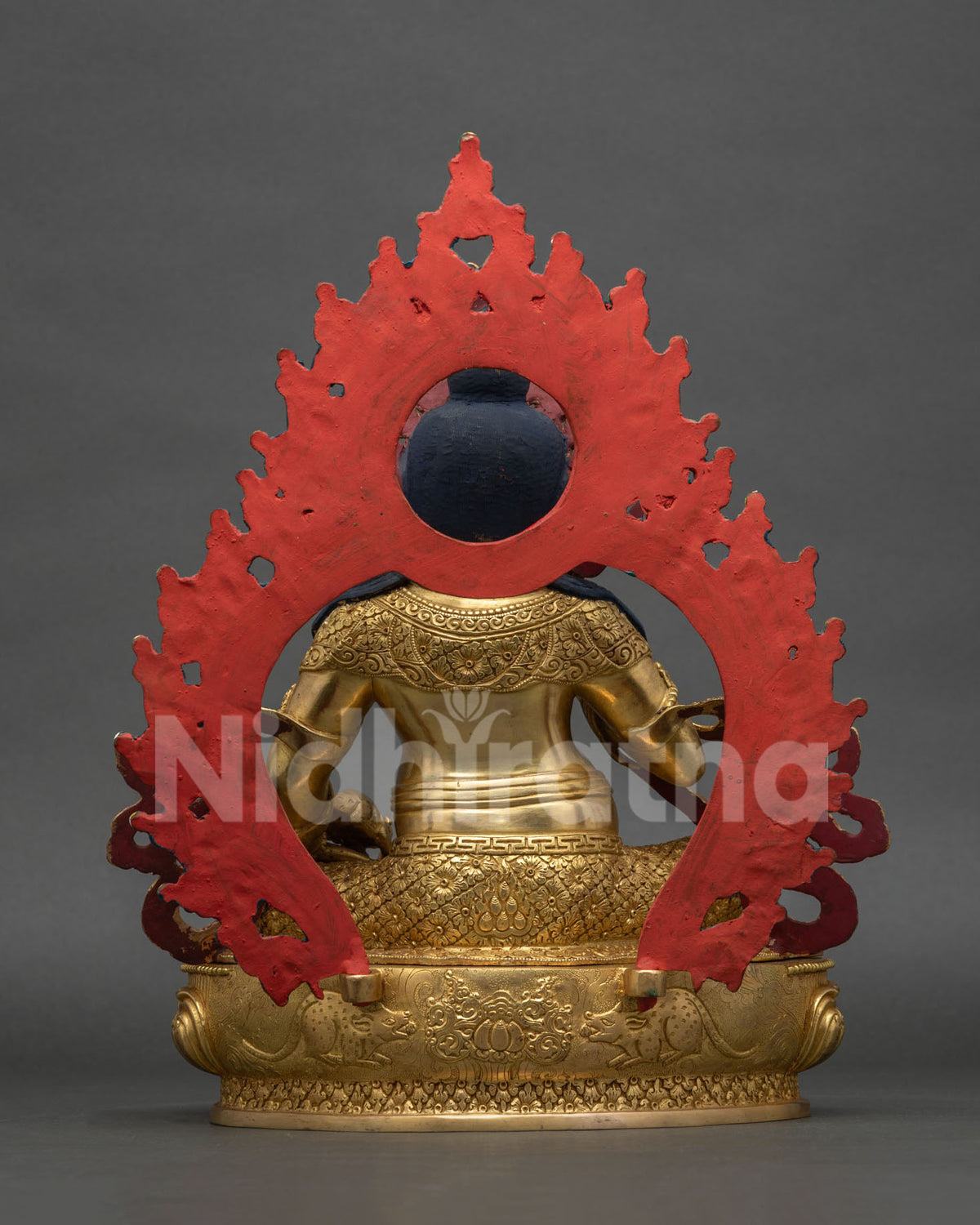 Back view of handmade copper Dzambhala statue showing intricate metalwork and halo