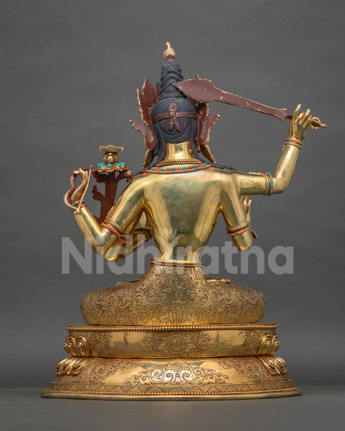 Back view of Maha Manjushri statue showing hand-engraved lotus pedestal and gold fire-gilded copper