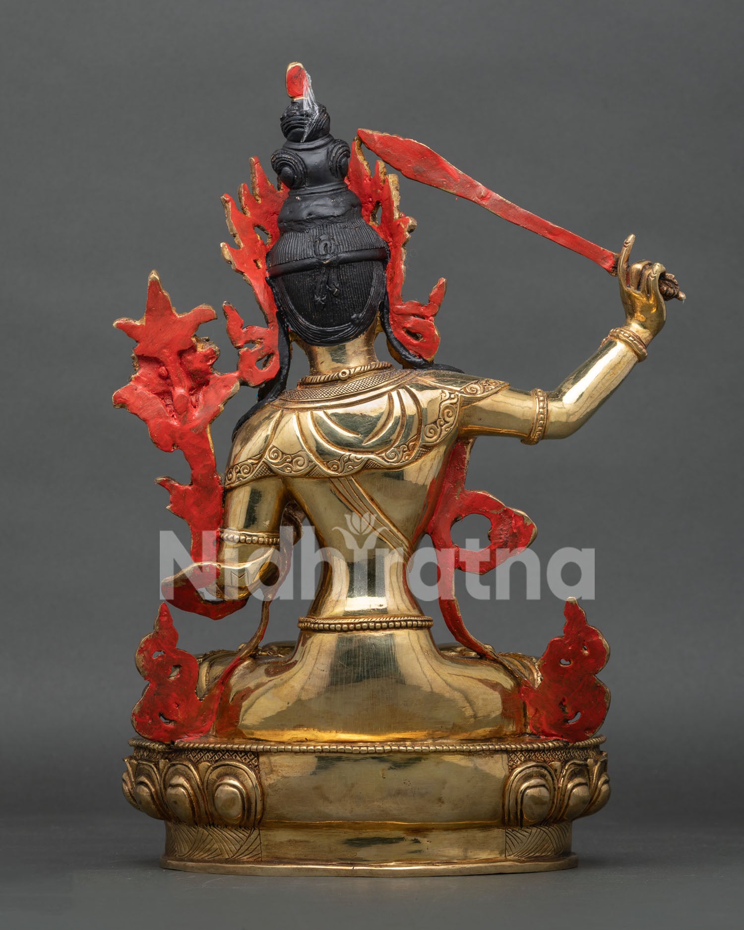 Back view of Manjushri statue displaying ornate halo and traditional copper craftsmanship