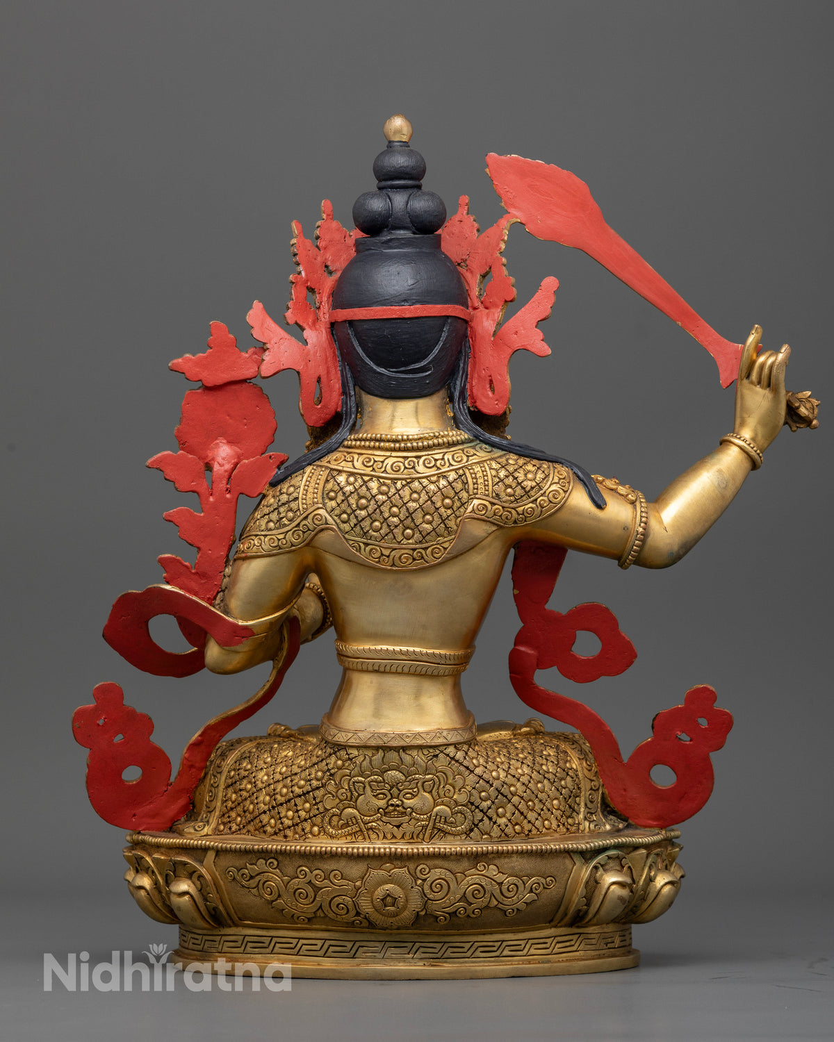 Back view of Manjushri statue showing carved mythical creature and floral motifs, engraved lotus pedestal, handcrafted Newari sculpture