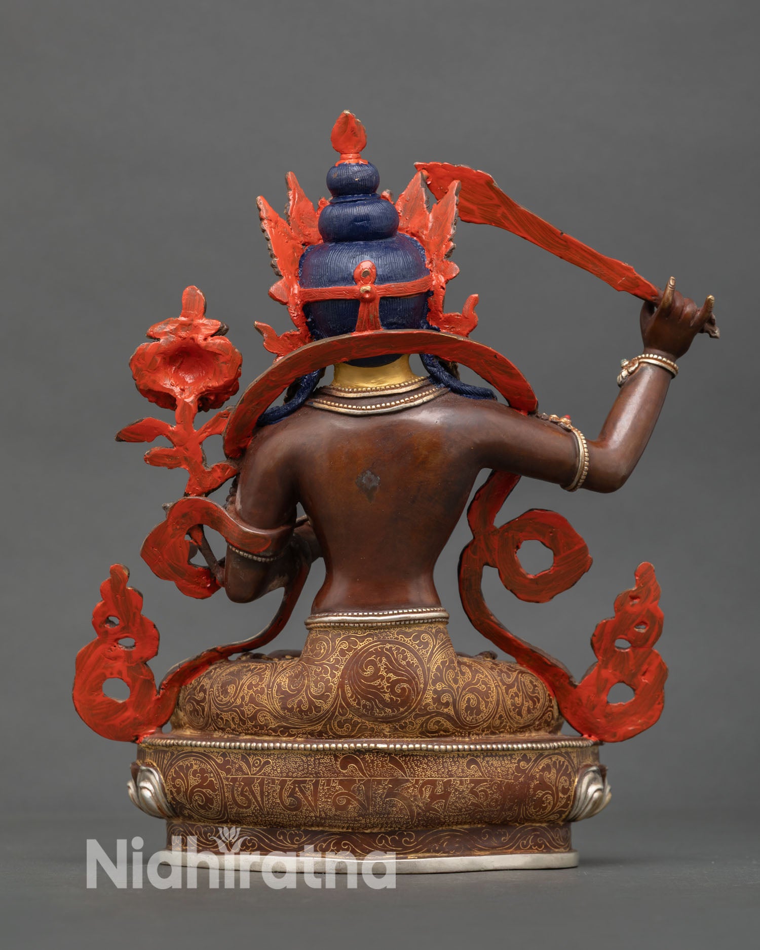 back view of manjushri statue with engraved lotus seat and sacred mantra inscription