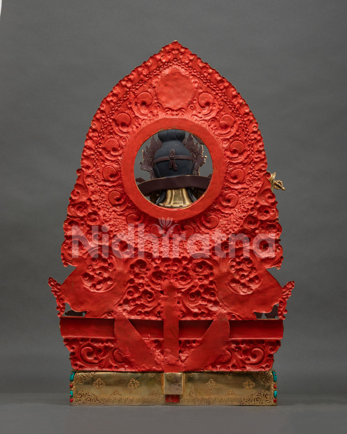 Back view of Manjushri statue with red-painted repousse halo and engraved gold-gilded base