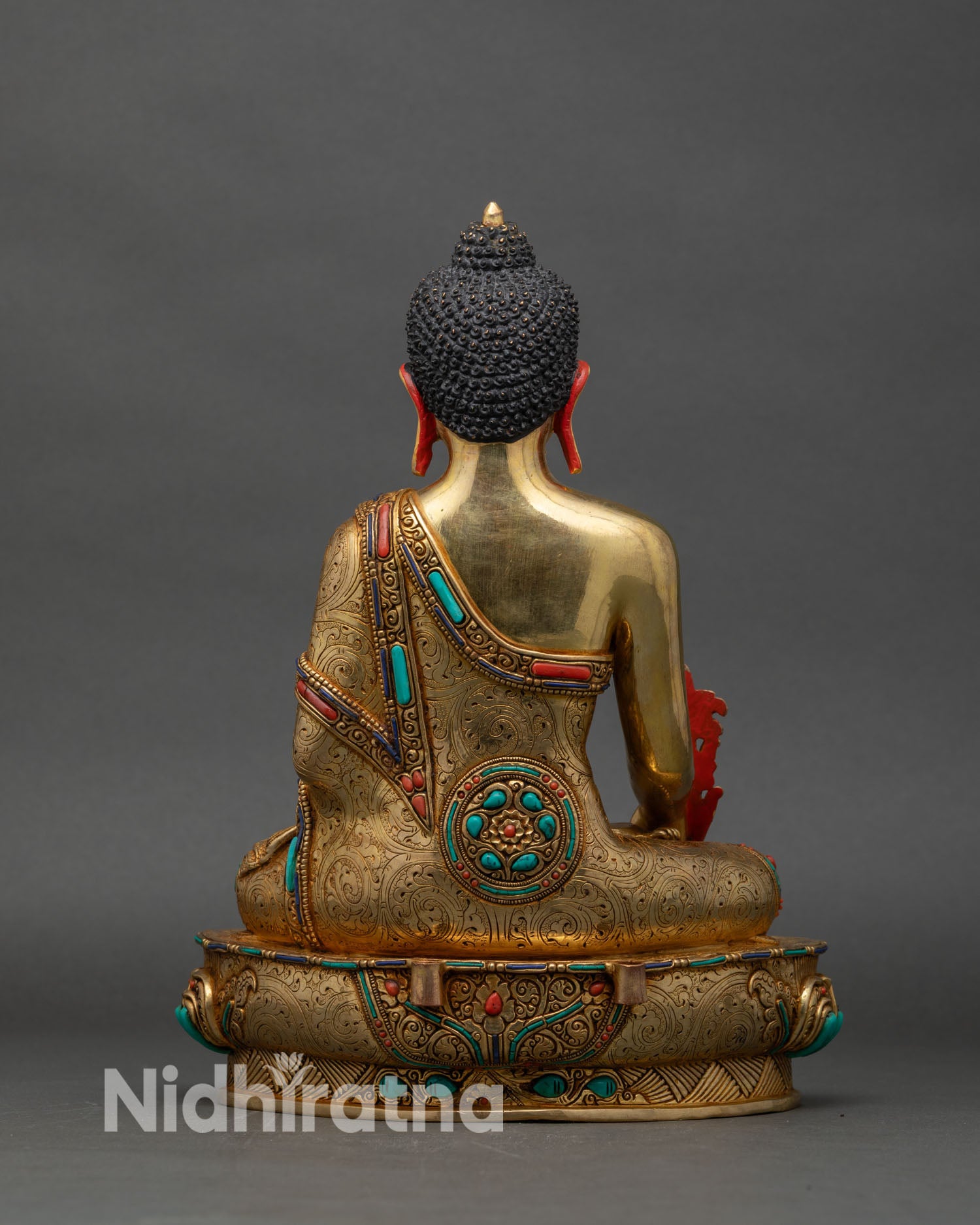 Back view of Medicine Buddha statue showing detailed halo and hand-engraved robes