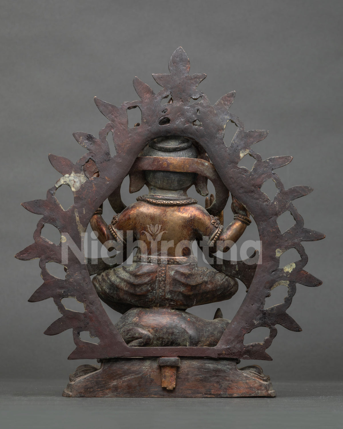 Back view of oxidized copper Ganesha statue showing rear halo and detailed patina finish