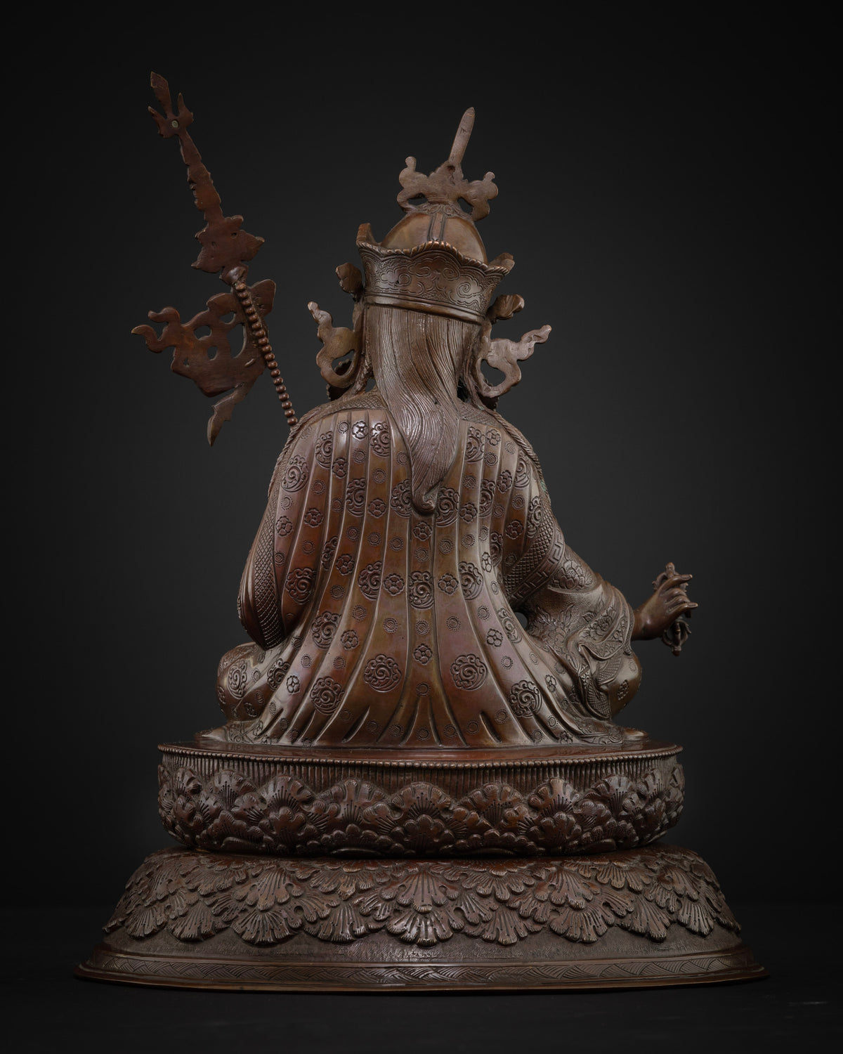 Back view of oxidized copper Guru Rinpoche statue showing engraved robe and lotus base