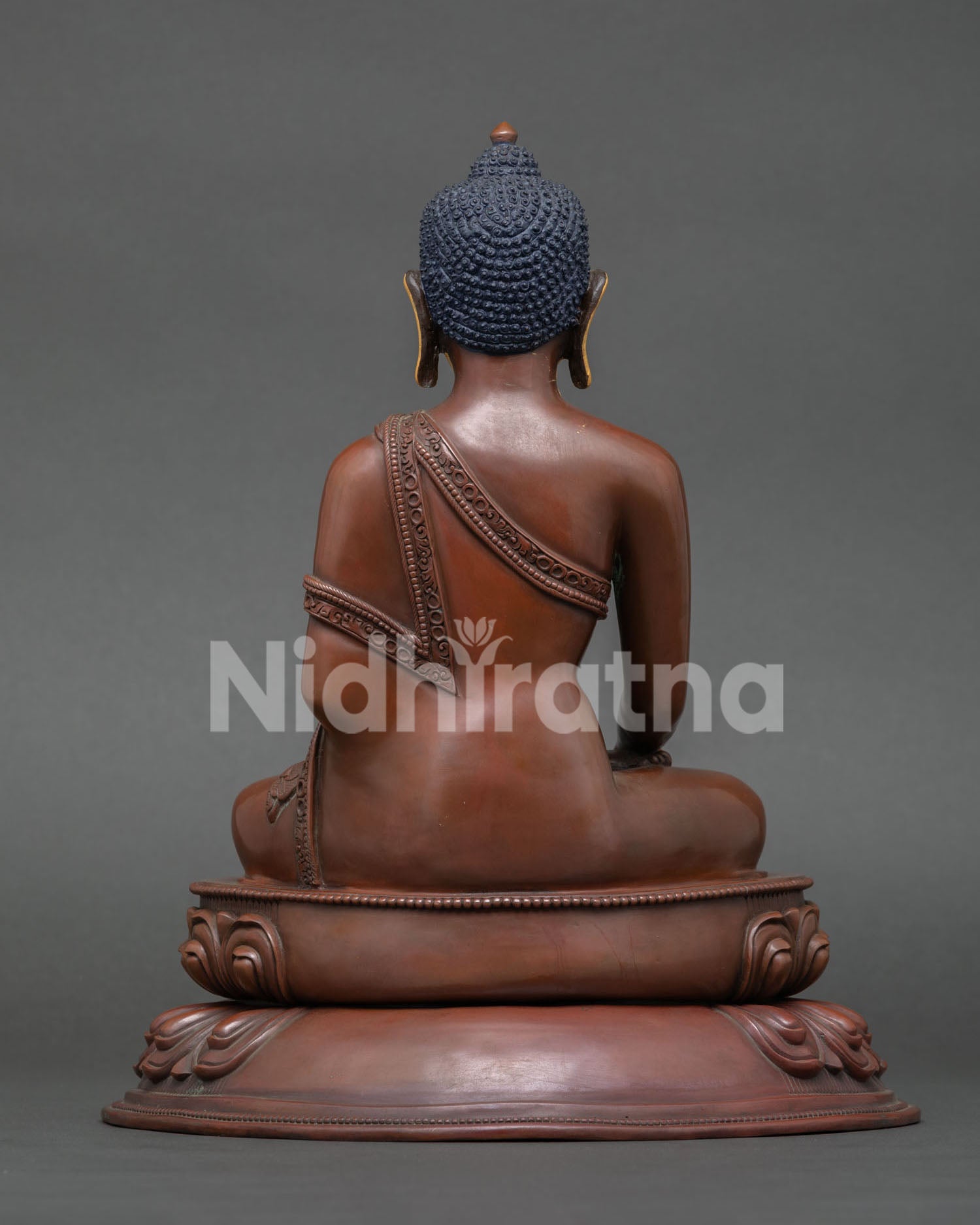back view of oxidized copper shakyamuni buddha statue with lotus base