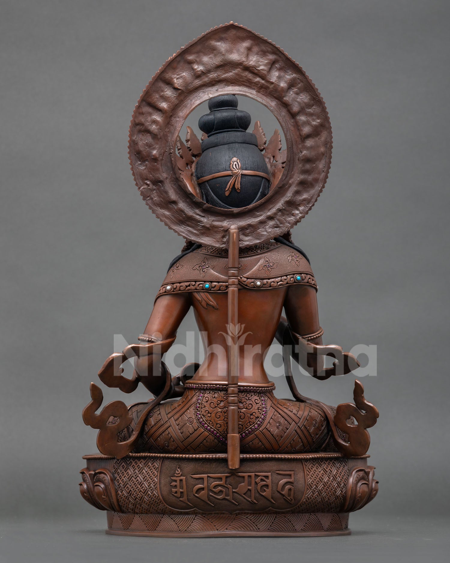 Back view of oxidized Vajrasattva statue with detailed carvings and lotus seat