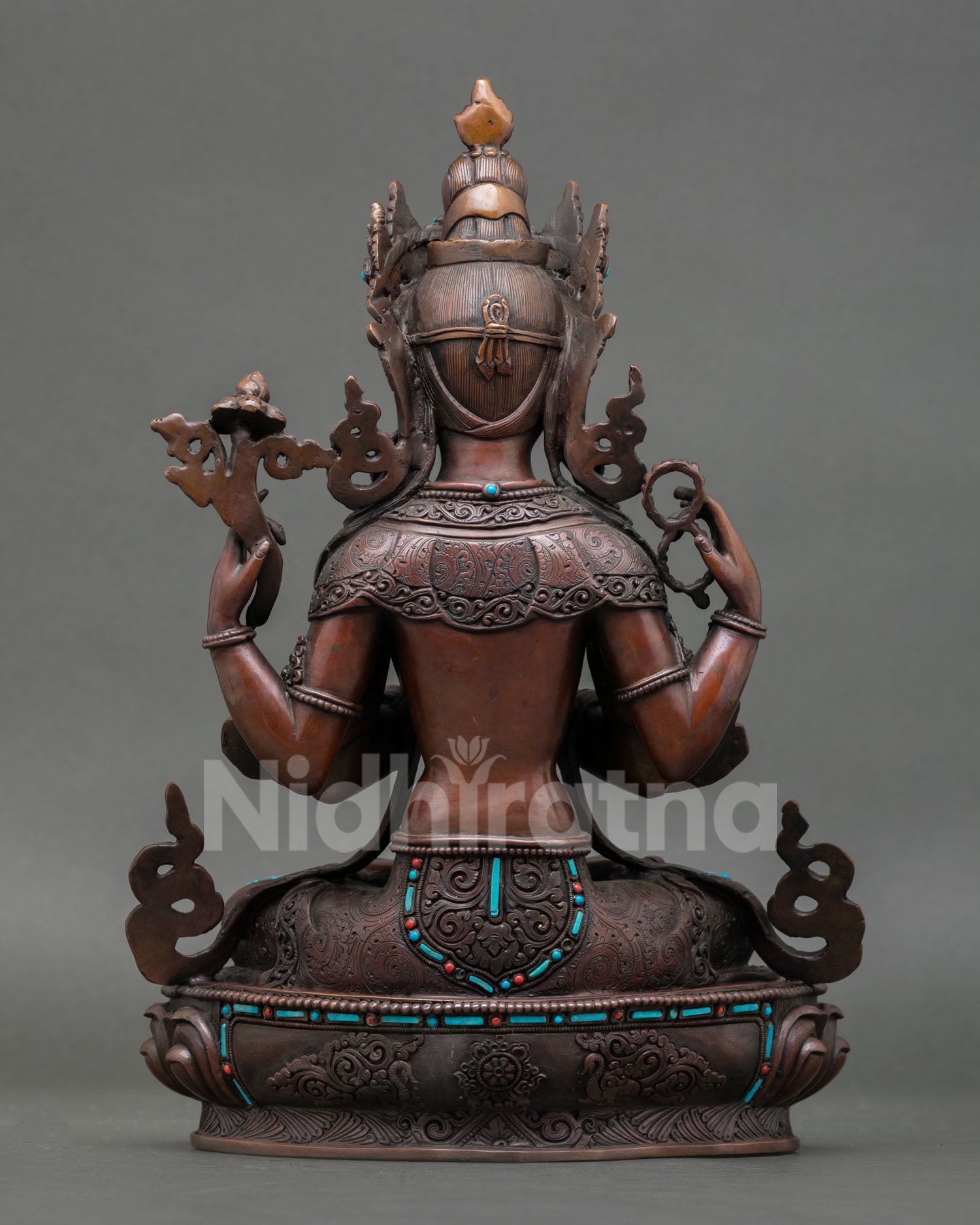 Back view of sacred Chenrezig statue from Patan Nepal showing traditional metal artistry oxidized texture and detailed lotus base