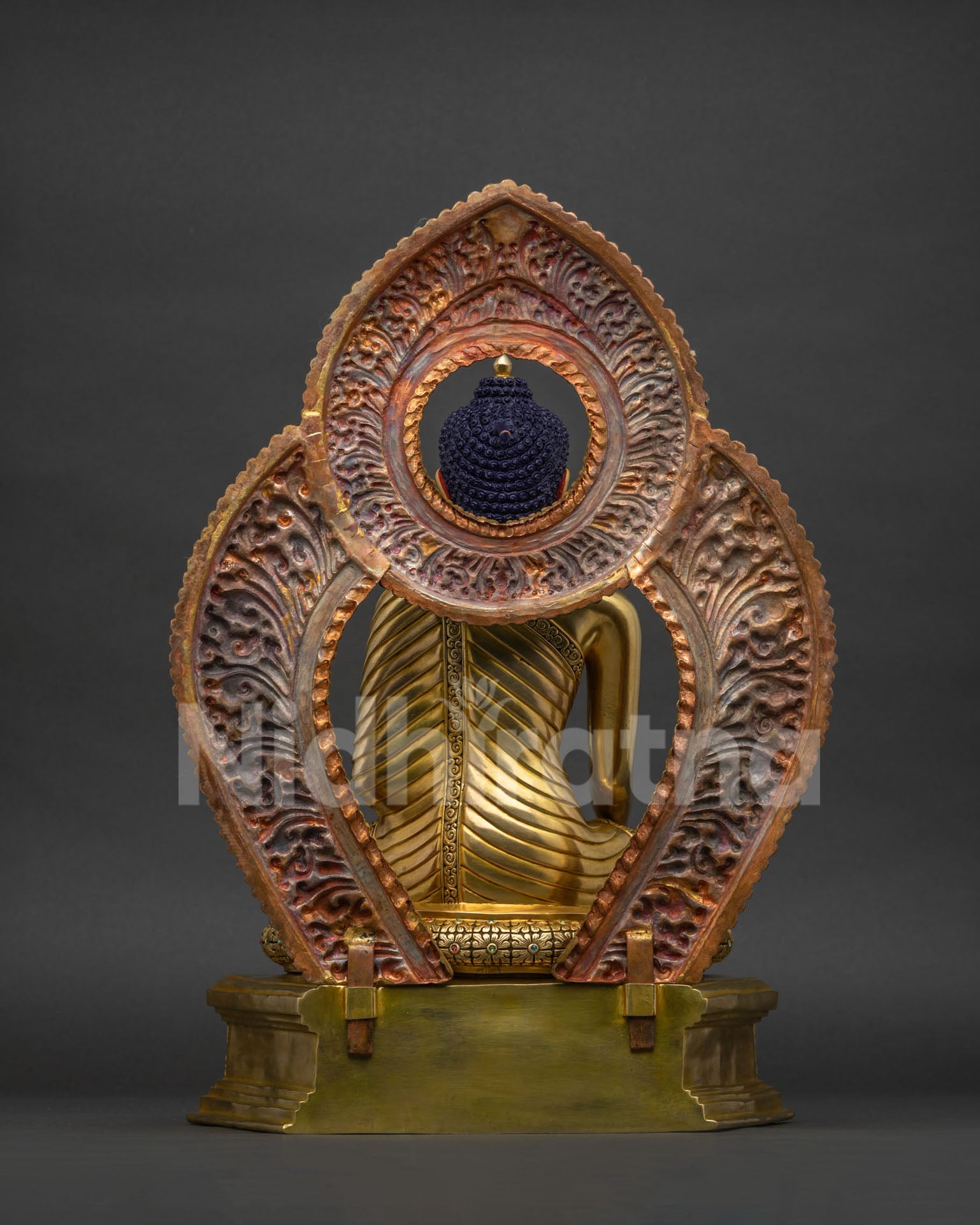 Back view of Shakyamuni Buddha copper statue showing lotus pedestal and carved throne