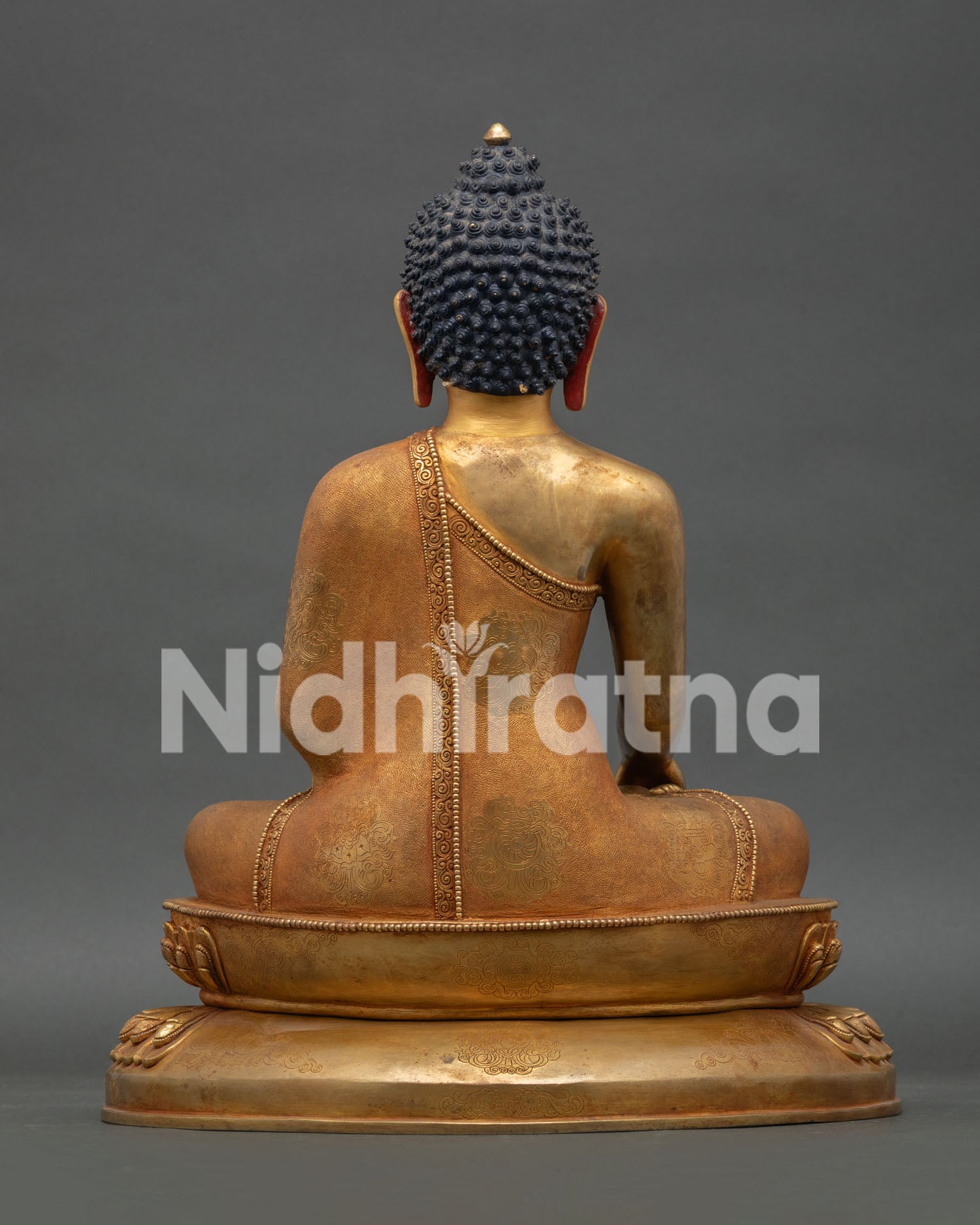 Back view of Shakyamuni Buddha statue featuring detailed robe carvings and copper craftsmanship