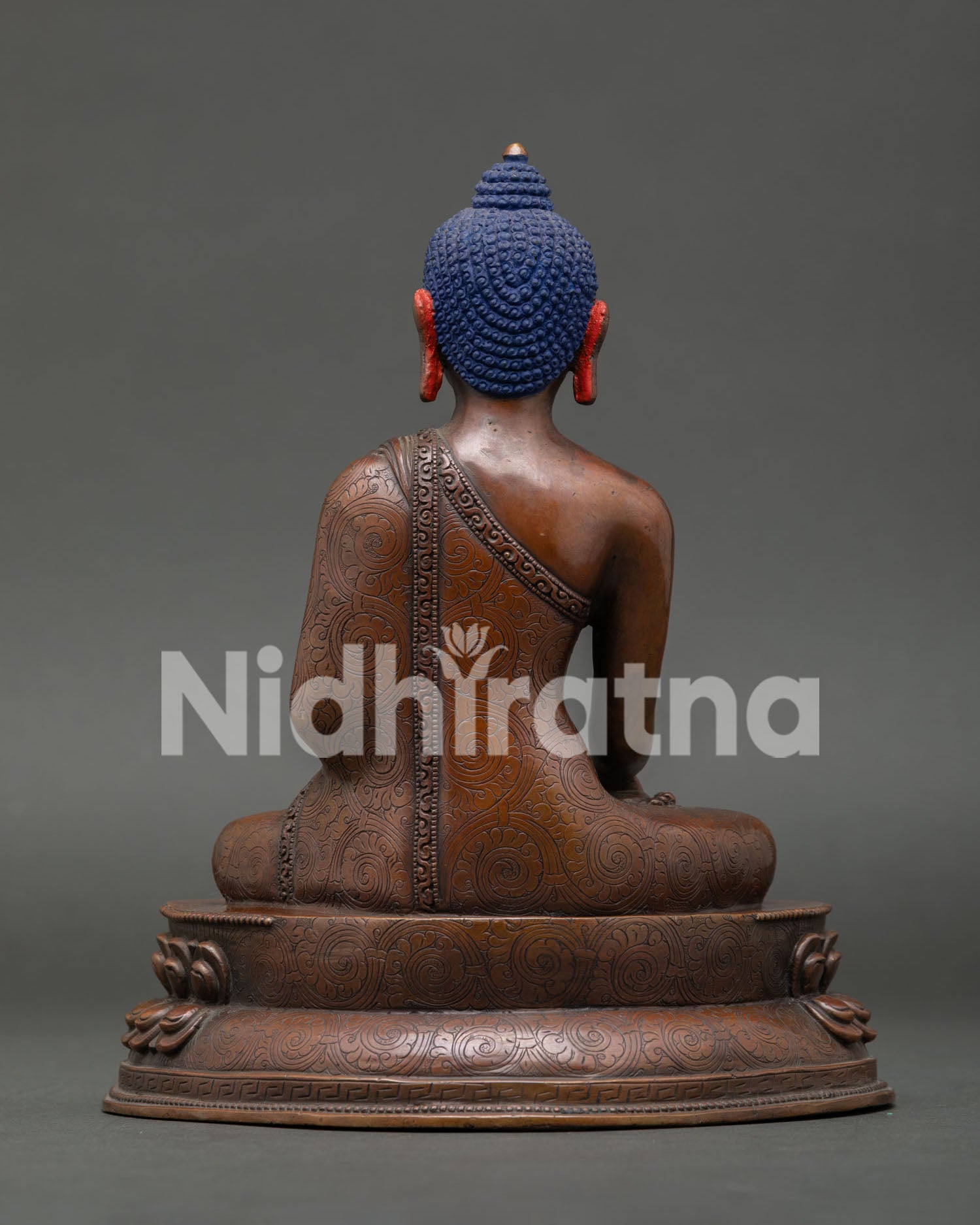 Back view of Shakyamuni Buddha statue highlighting oxidized copper finish and handcrafted robe details.