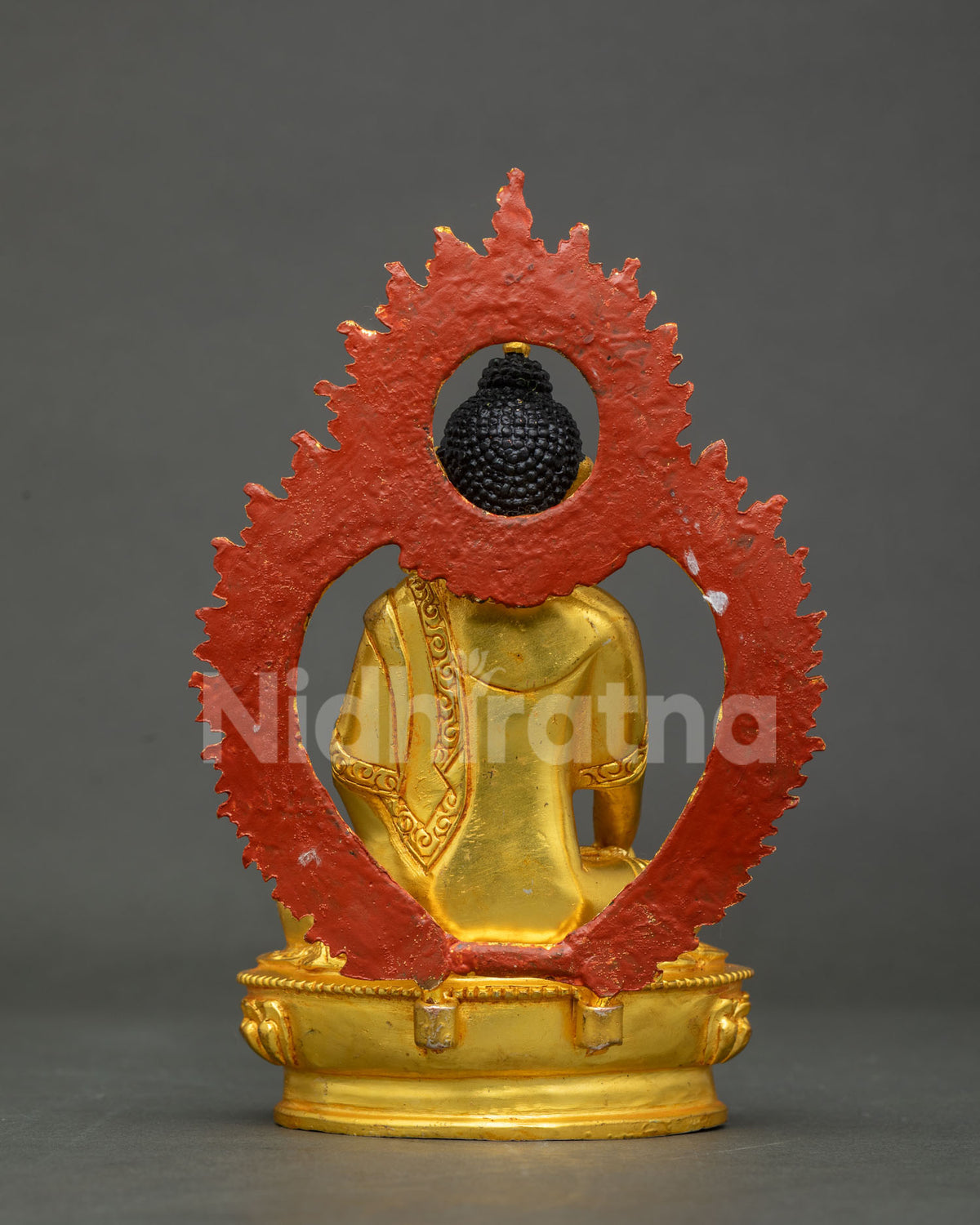 Back view of Shakyamuni Buddha statue showing the detailed gold-gilded halo