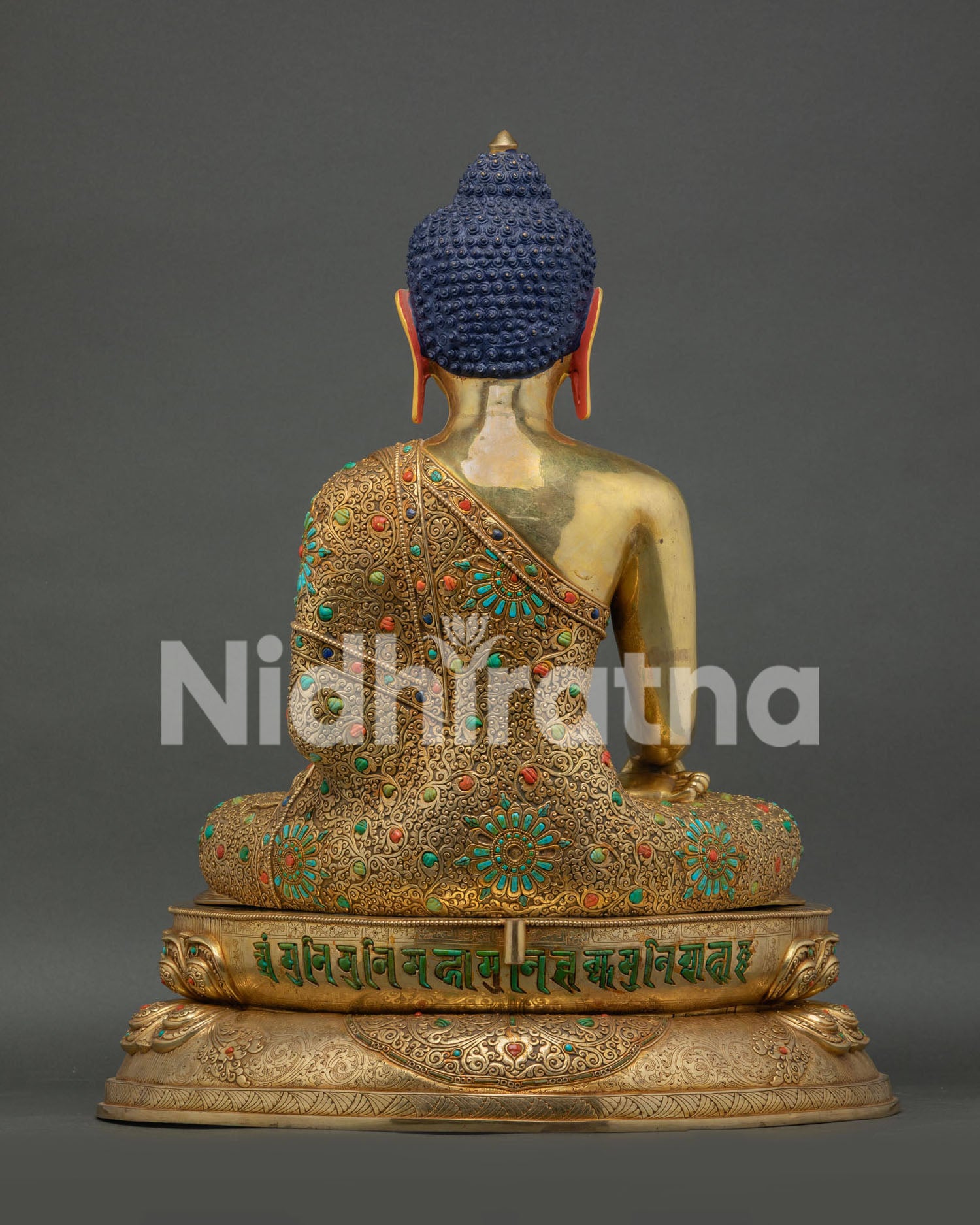 Back view of Shakyamuni Buddha statue showing hand carved robe and halo