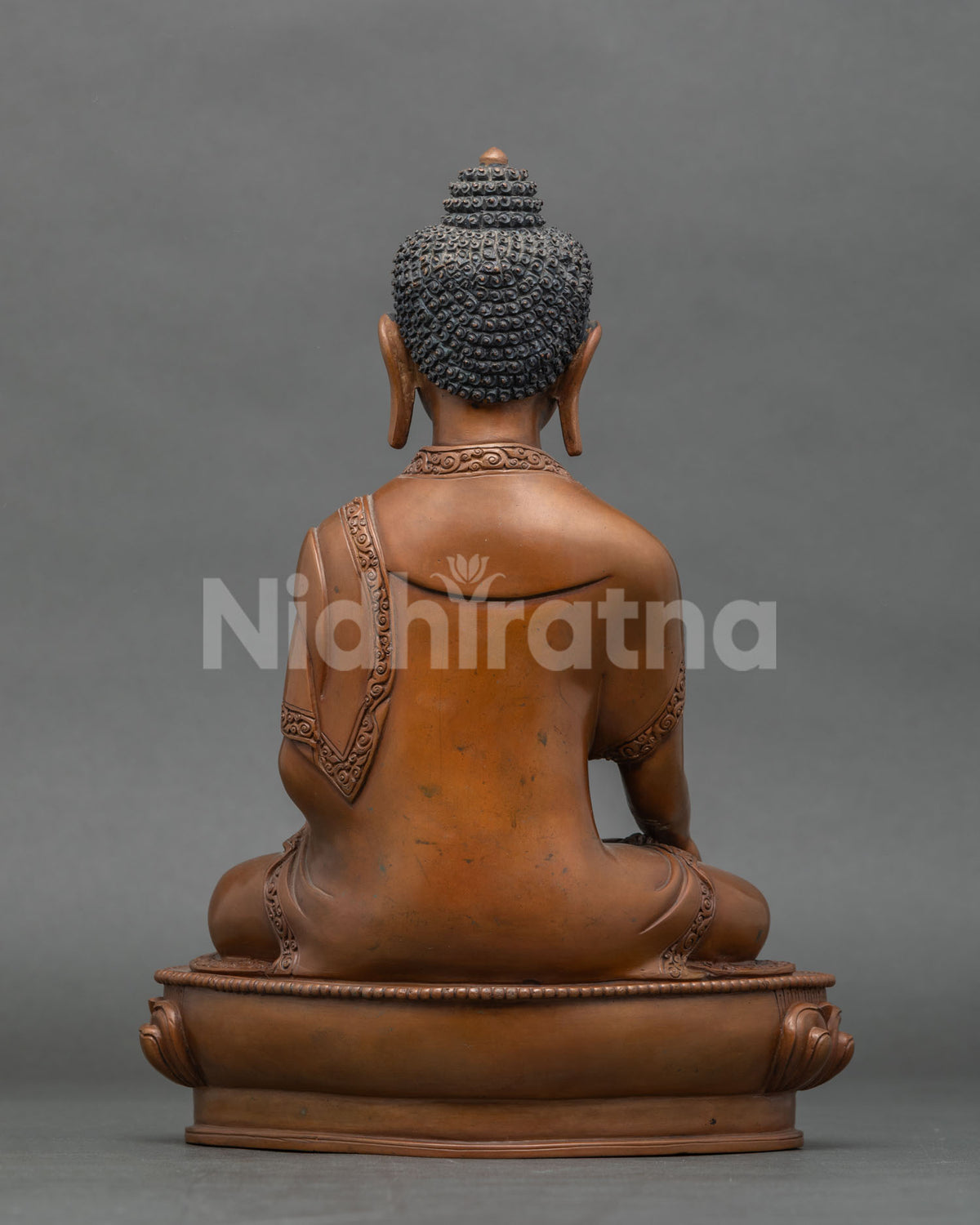 Back view of Shakyamuni Buddha statue showing hand cast copper detail and oxidized brown finish