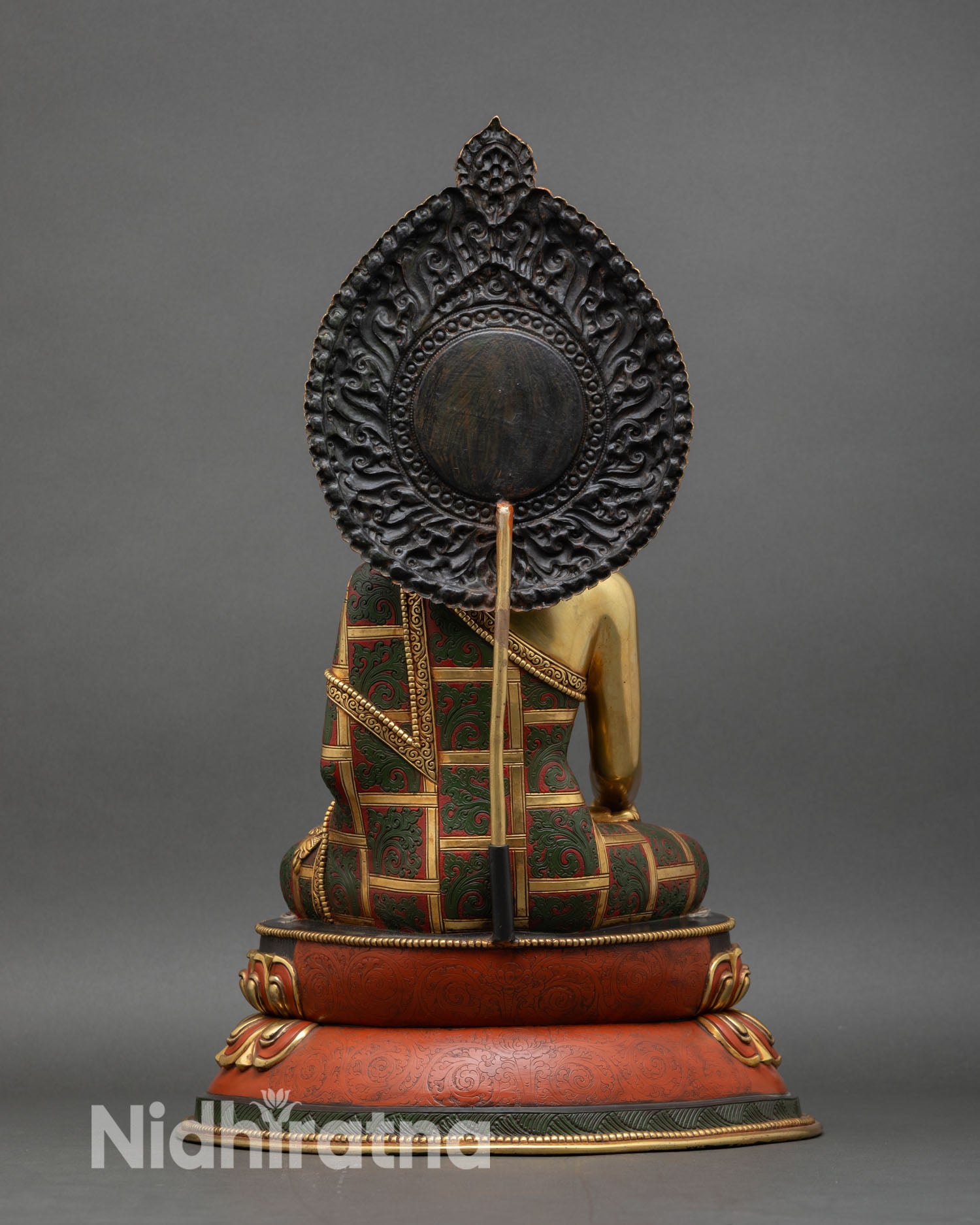 back view of shakyamuni buddha statue with carved torana and lotus base detailing