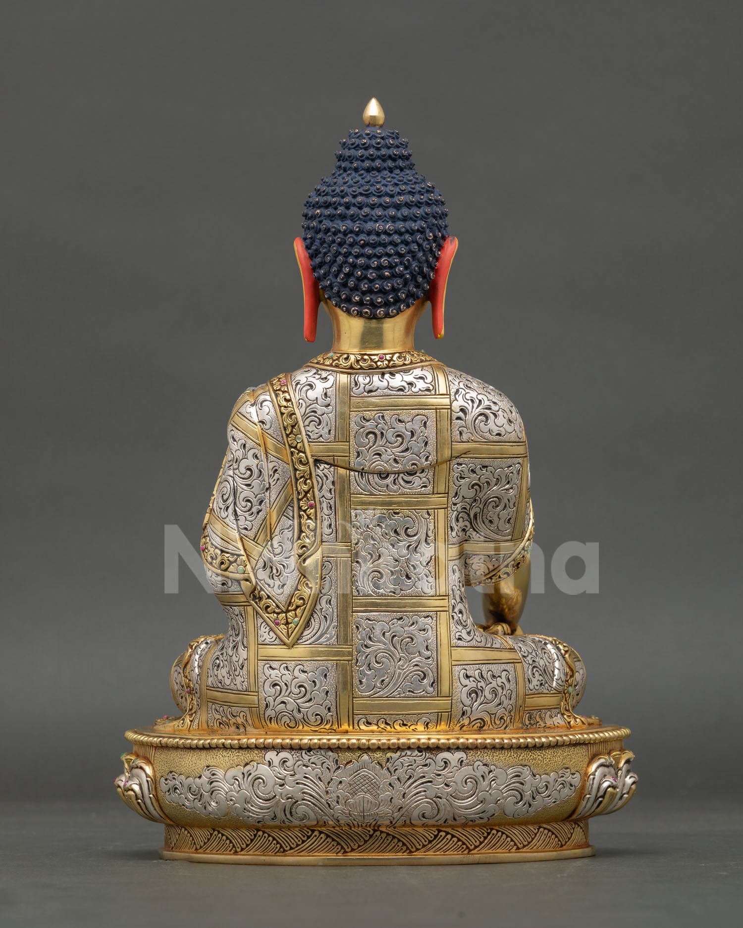 Back view of Shakyamuni Buddha statue with engraved robe and lotus base