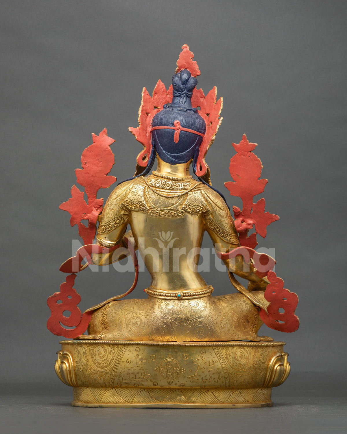 Back view of the Arya Tara statue showing hand-chased robe engravings and an engraved lotus pedestal