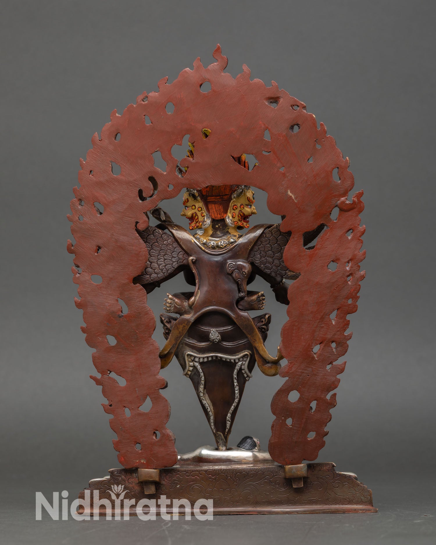 Back view of Vajrakilaya statue with halo and wings in oxidized copper, a symbol of Himalayan spiritual protection.