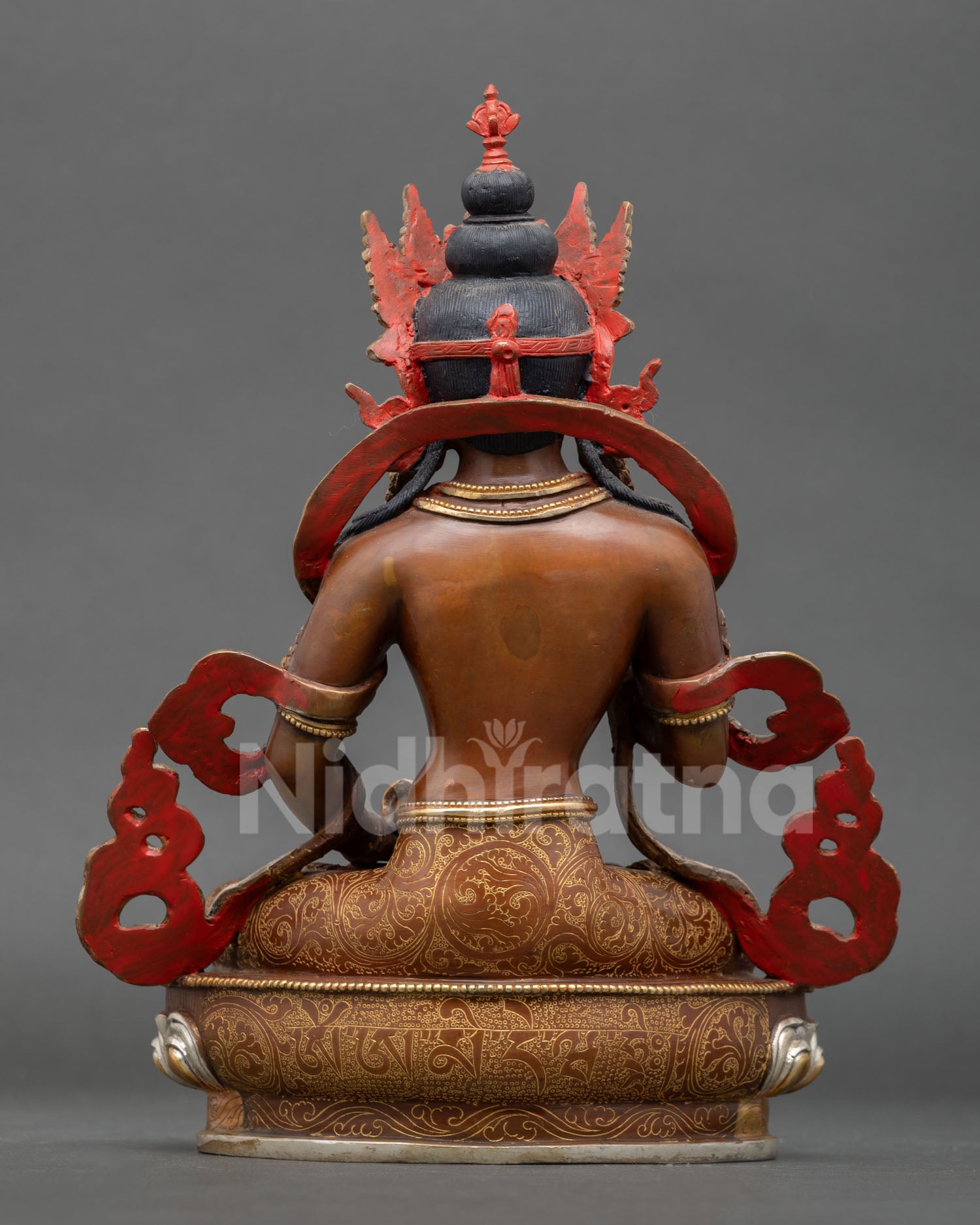 back view of vajrasattva statue with intricate robe carvings and lotus base