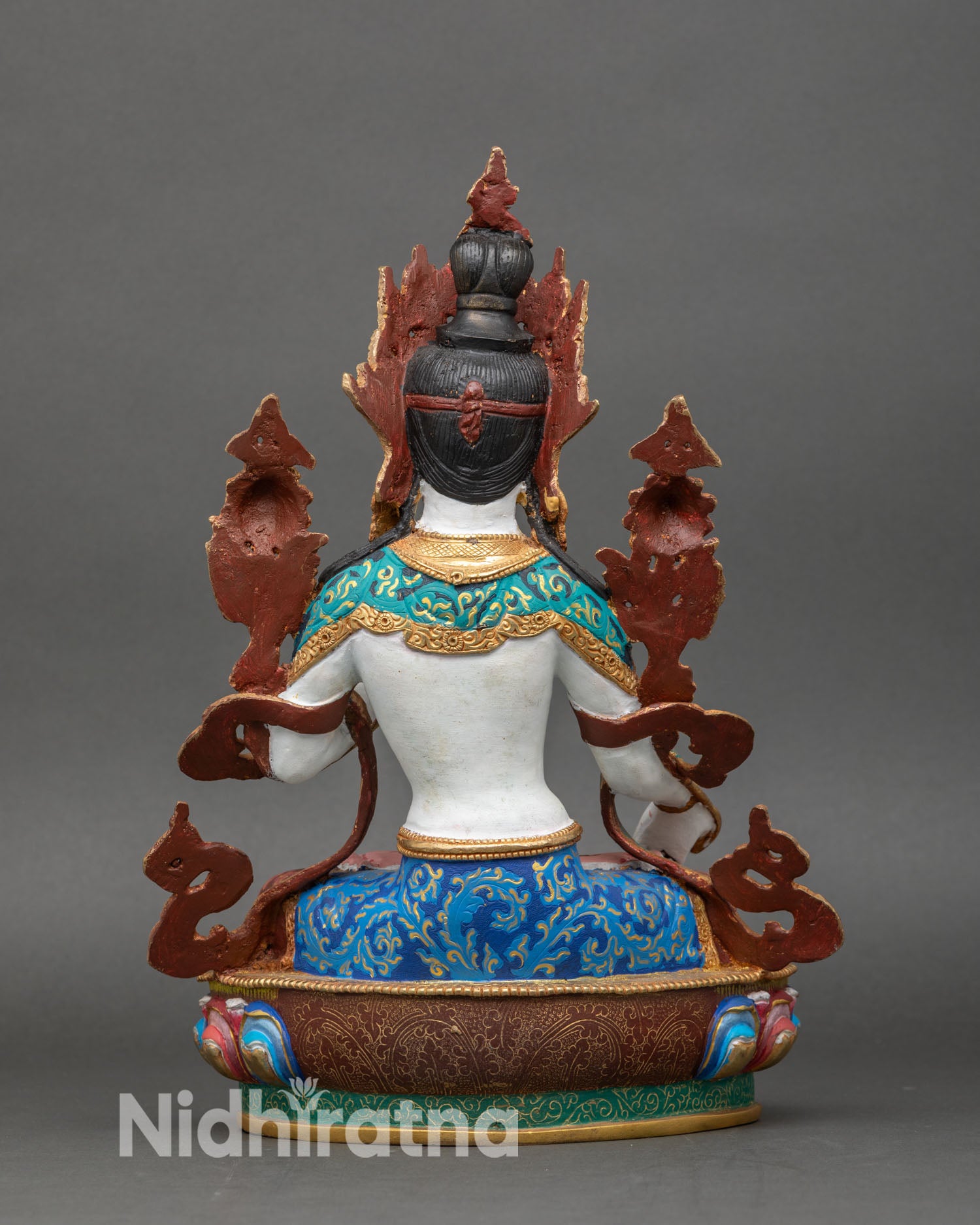 back view of white tara statue showing multicolored garments and lotus pedestal design
