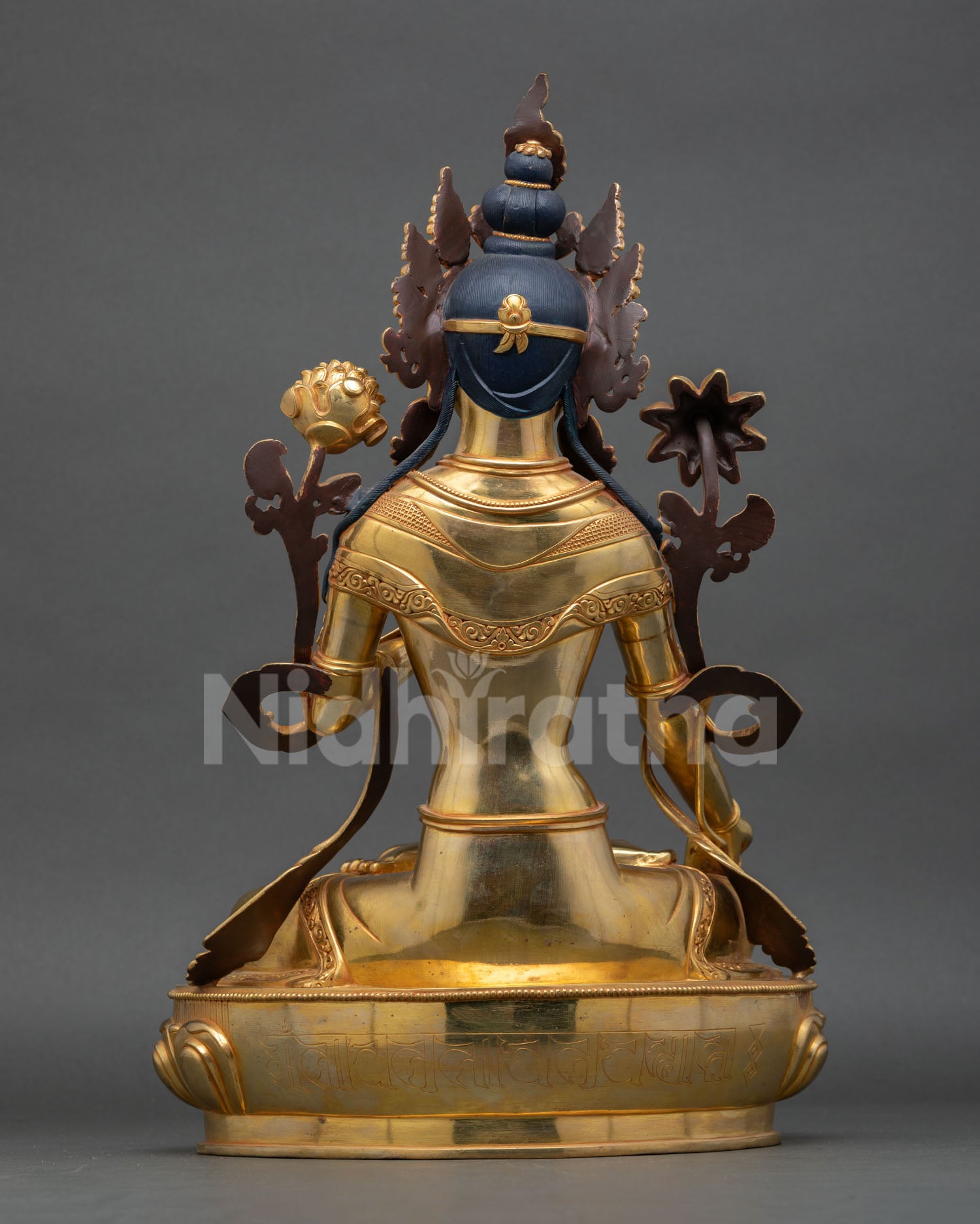 back view of white tara statue with engraved robe details and lotus pedestal