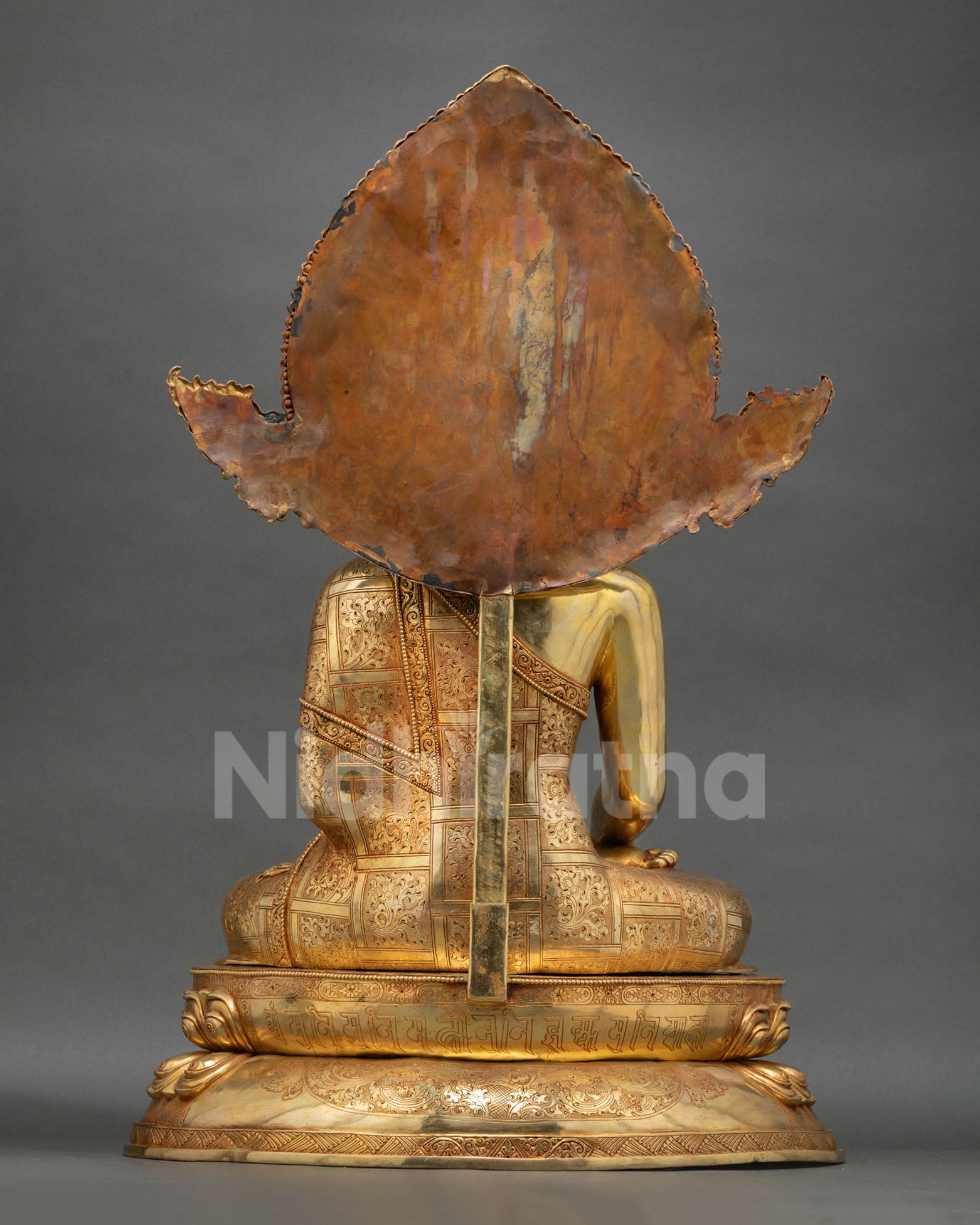 Back view sacred Buddha Shakyamuni statue with ornate halo decorated, handcrafted Nepalese Buddhist art for spiritual home and dharma space