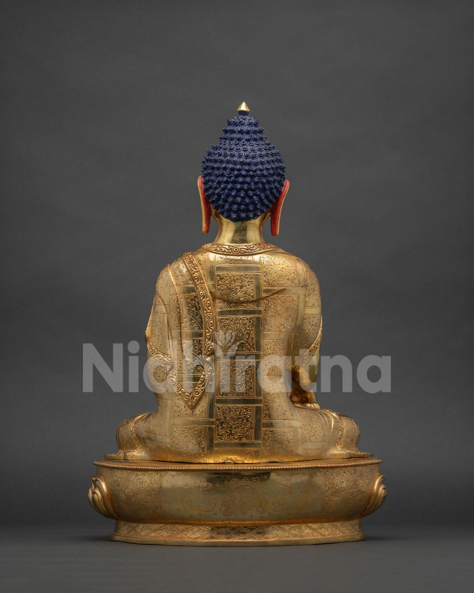 Back view of Shakyamuni Buddha copper statue with intricate gold gilded details and robes