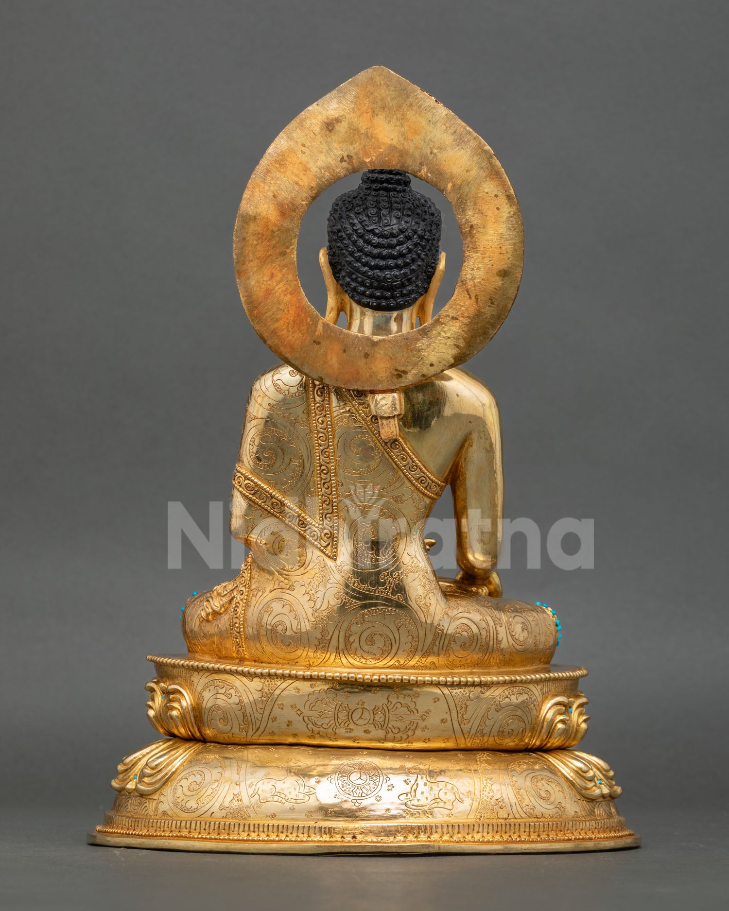 Back view of Shakyamuni Buddha statue with detailed halo and lotus base