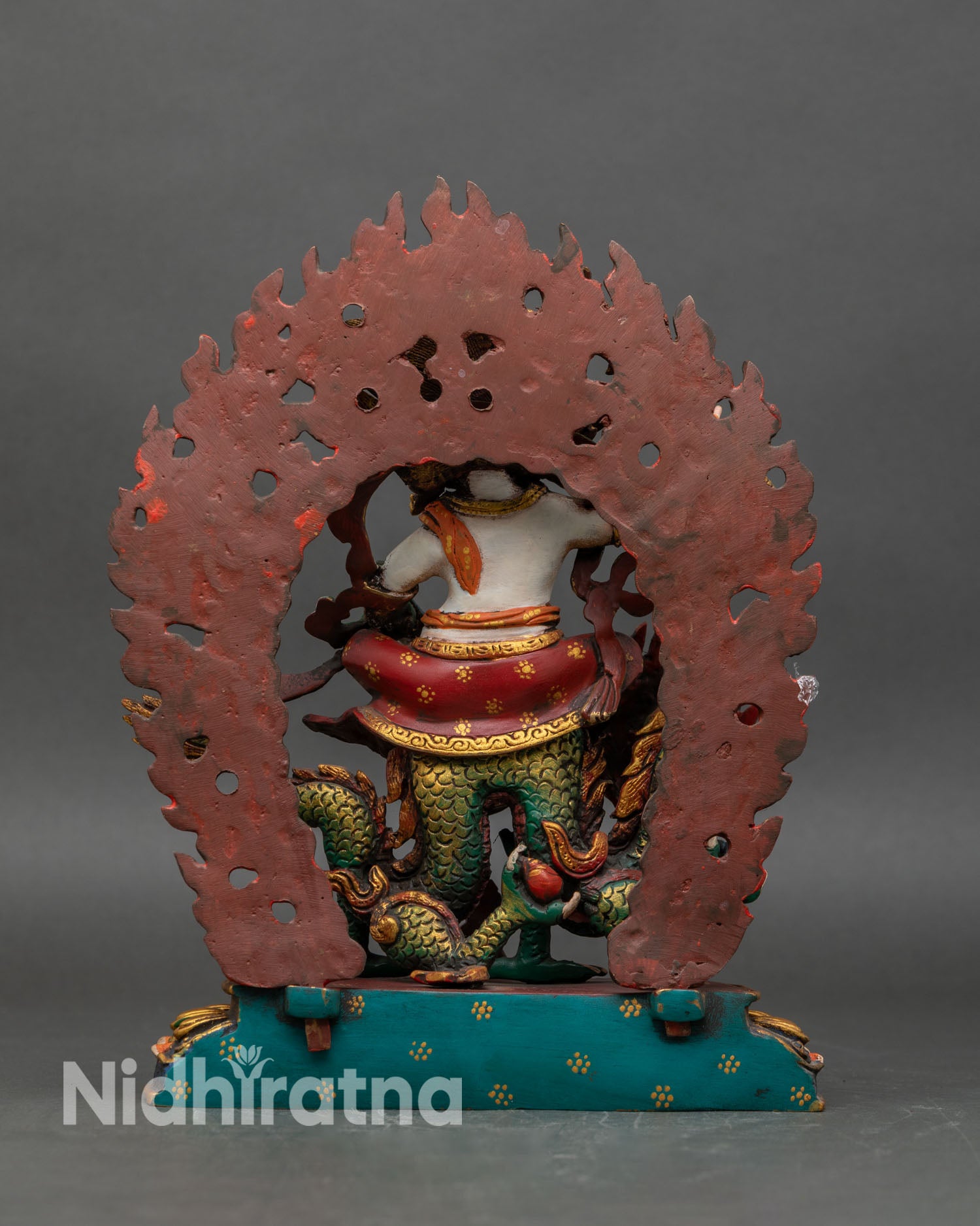 Back view of White Dzambhala statue showing ornate lotus base and aureole flames