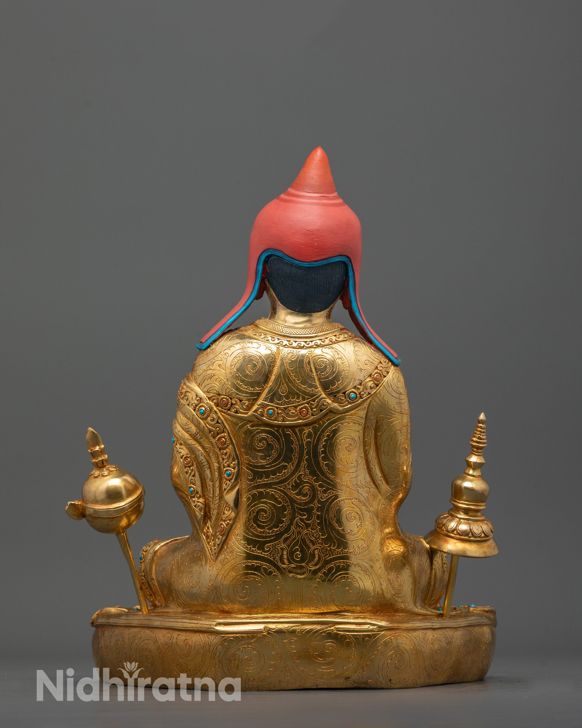 back view of Atisa statue highlighting detailed robe folds and fire-gilded copper craftsmanship
