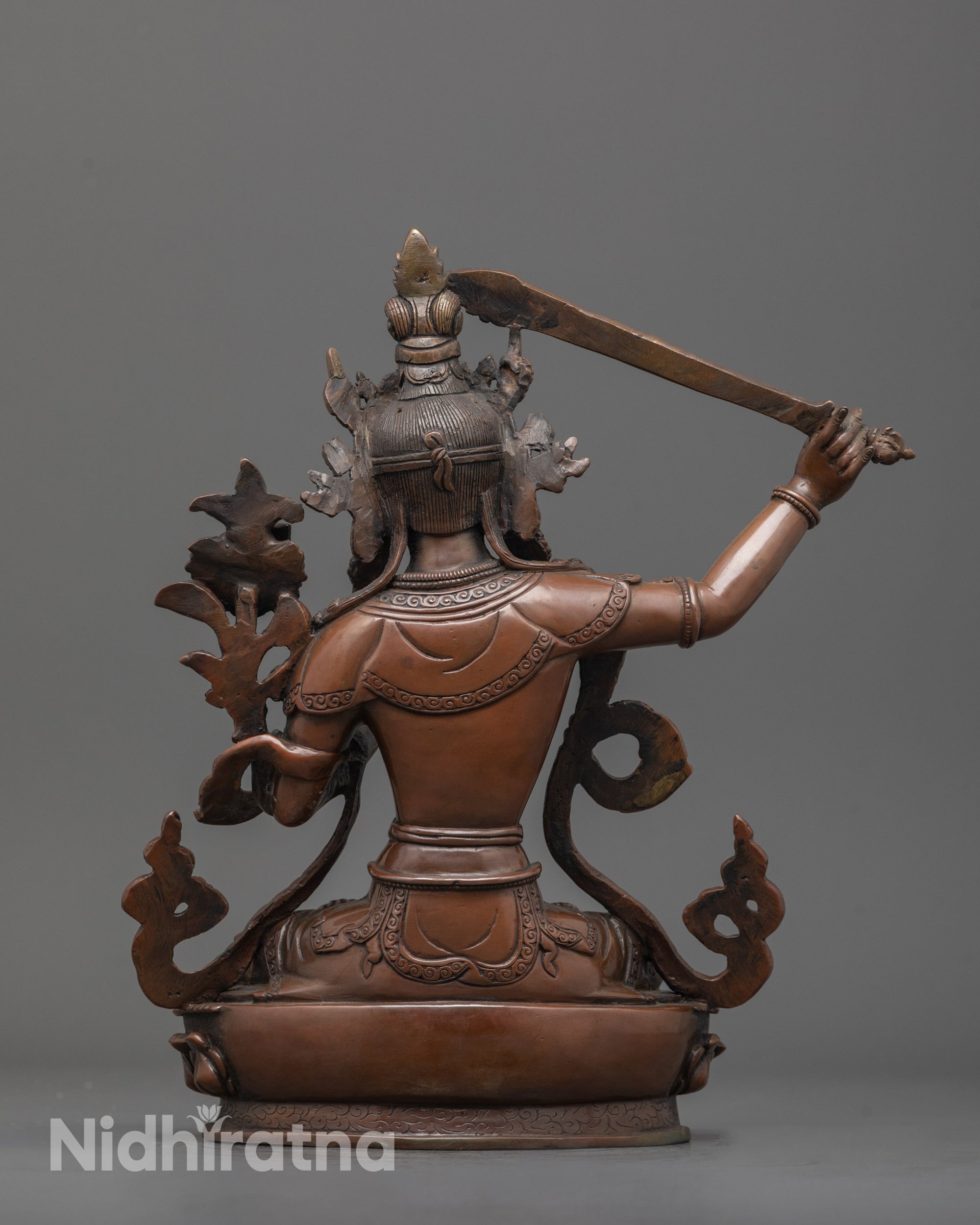 back view of Manjushri statue highlighting robe detail and hollow lotus base craftsmanship