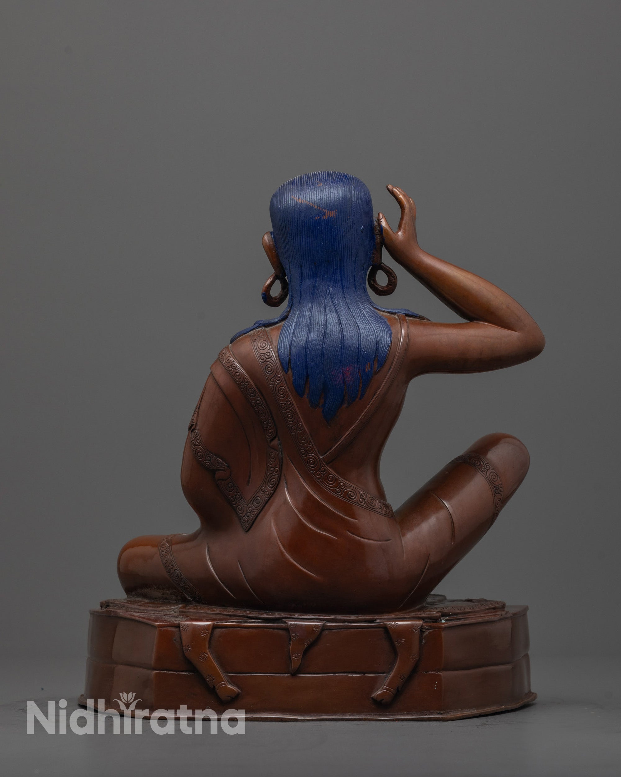back view of Tibetan Milarepa statue highlighting throne base and oxidized copper texture