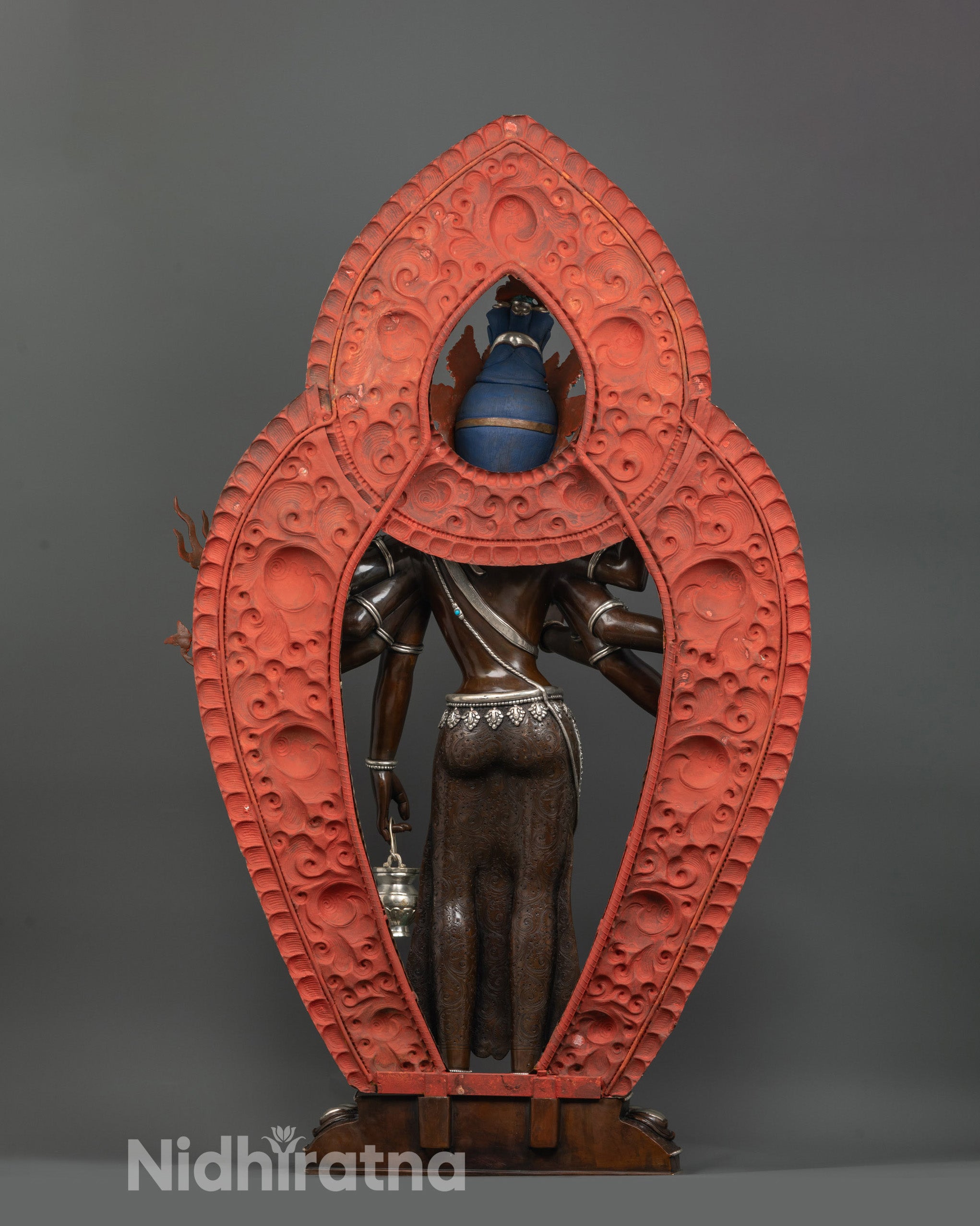 back view of amoghapasa lokeshvara statue displaying silver-plated halo with intricate patterns