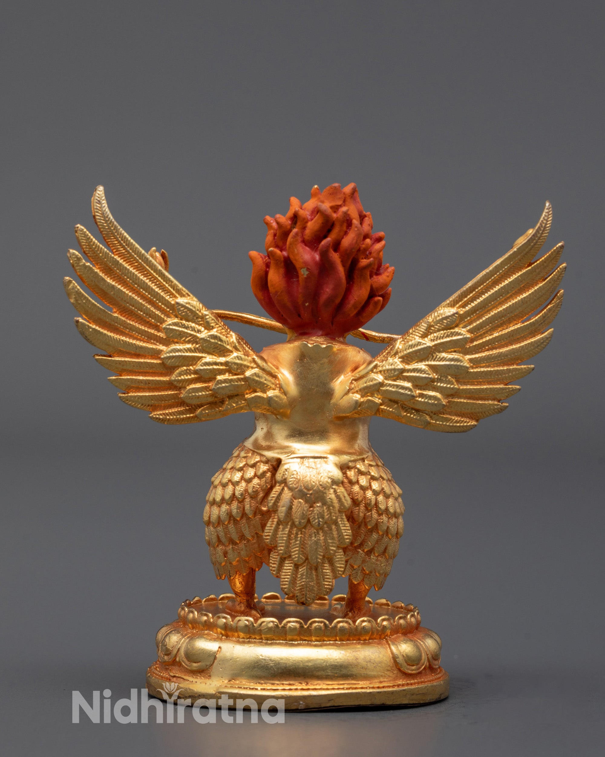 back view of gold-plated garuda statue with detailed feathers and wing structure