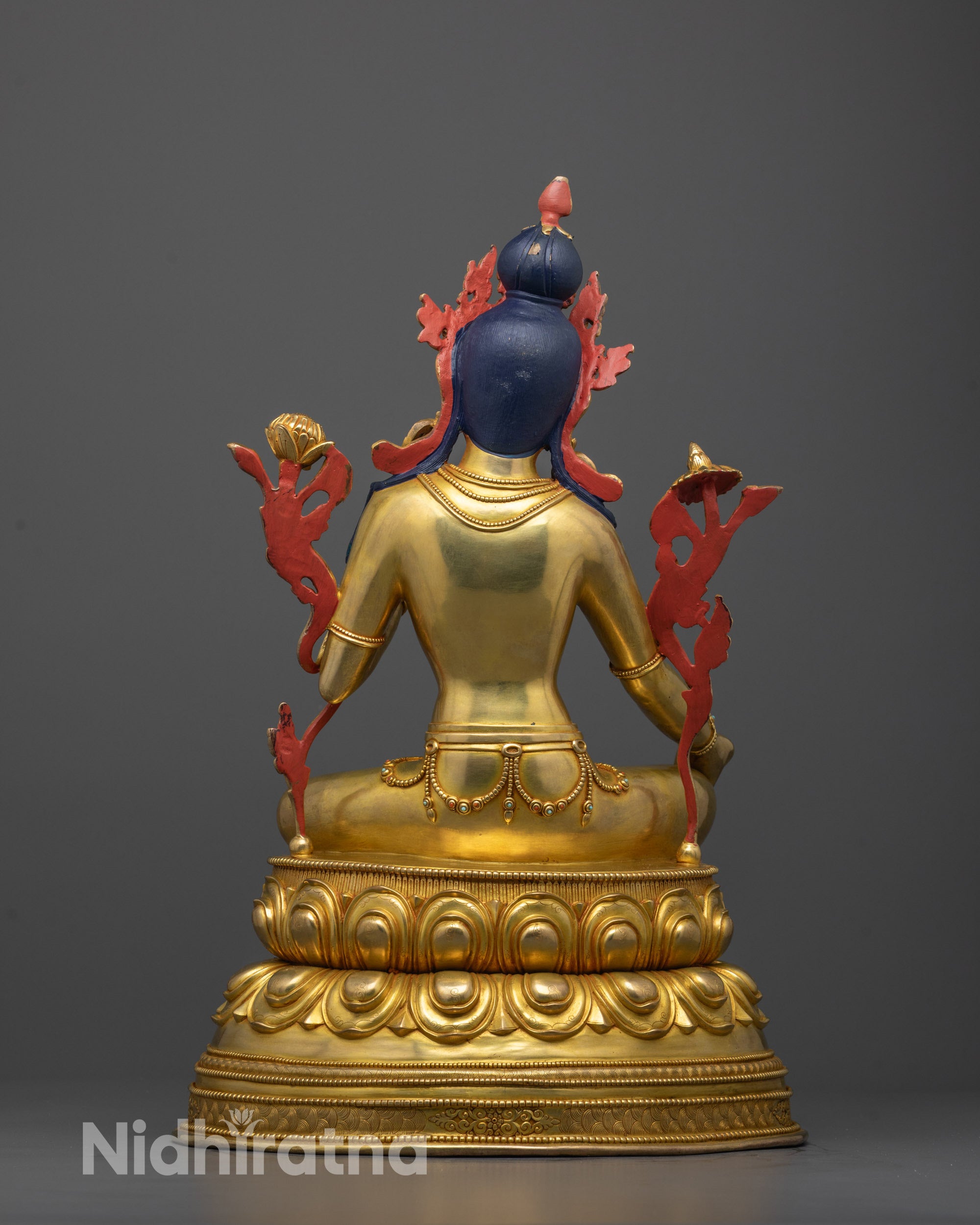 back view of green tara sculpture highlighting detailed carvings and fire-gilded copper finish