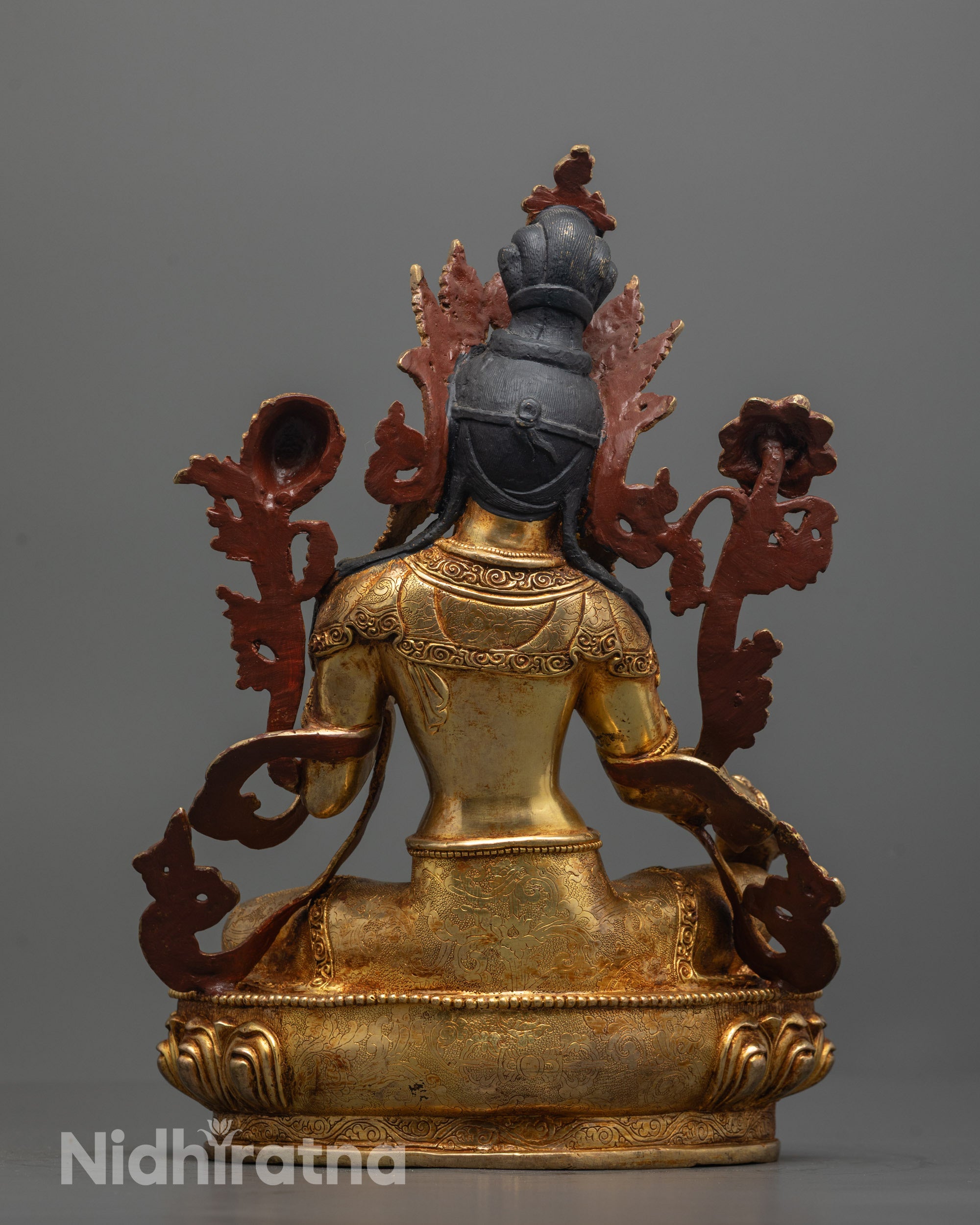 back view of green tara statue highlighting robe patterns and gold fire gilded copper base