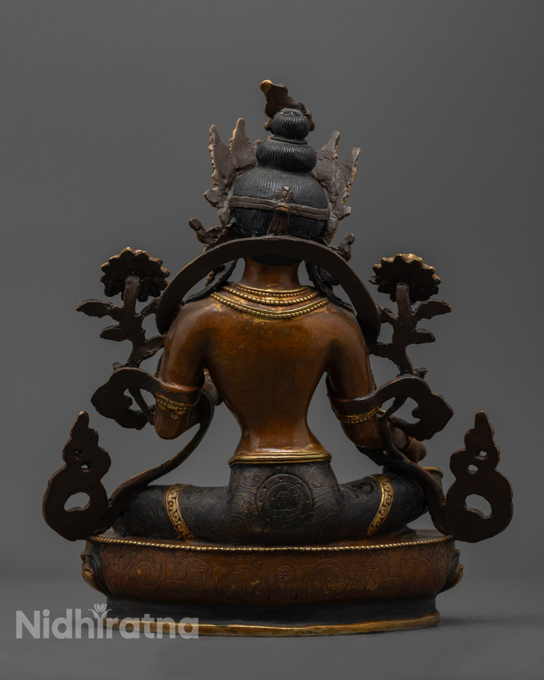 back view of green tara statue with gold-plated robe intricate lotus patterns and jewelry