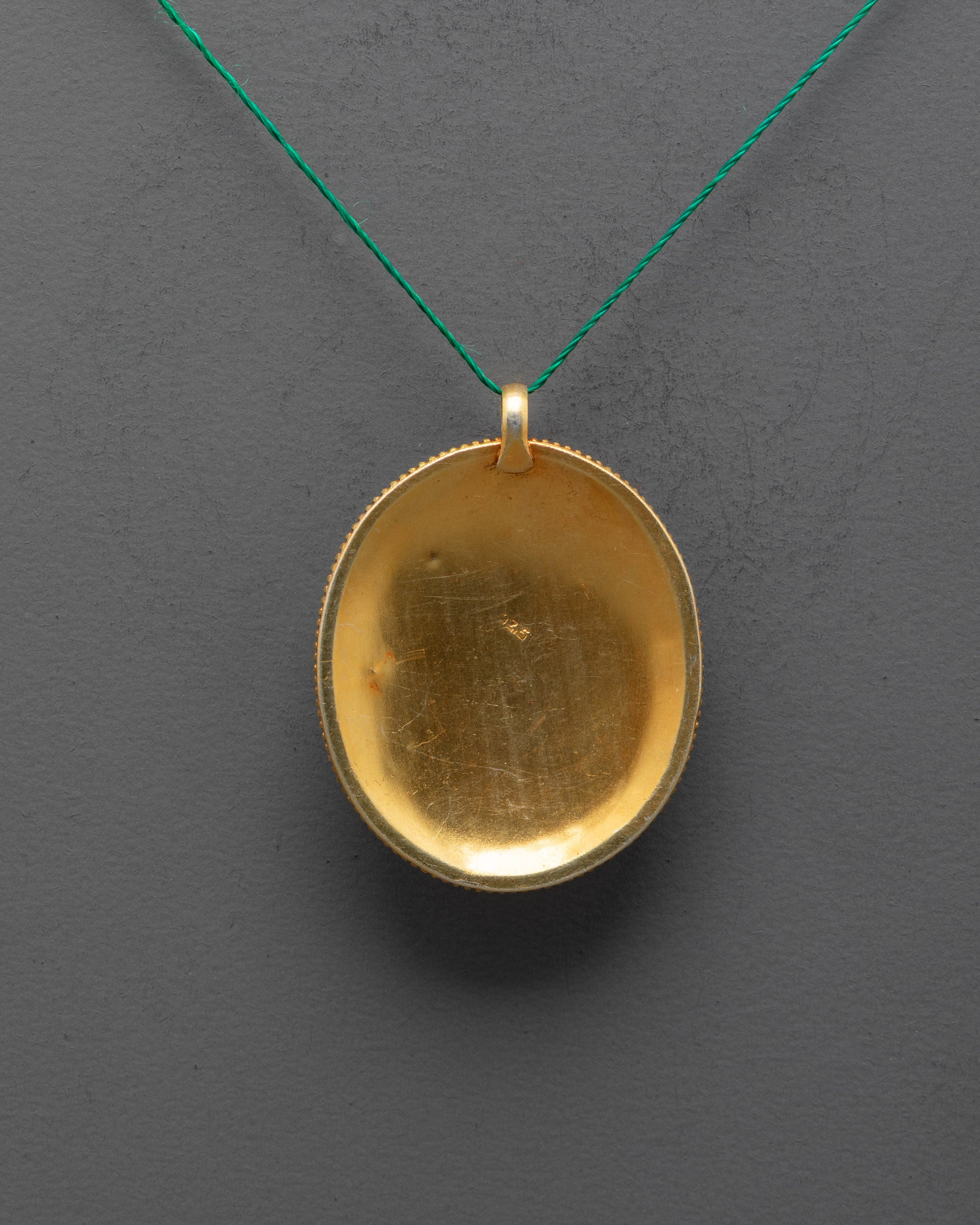 back view of handcrafted flower locket from Patan featuring detailed copper carving and design