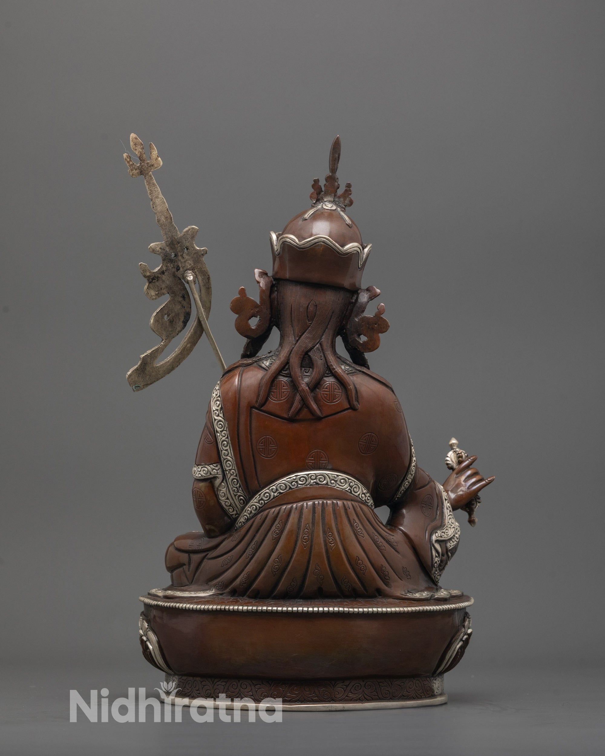 back view of handcrafted padmasambhava statue with detailed robe and oxidized copper texture