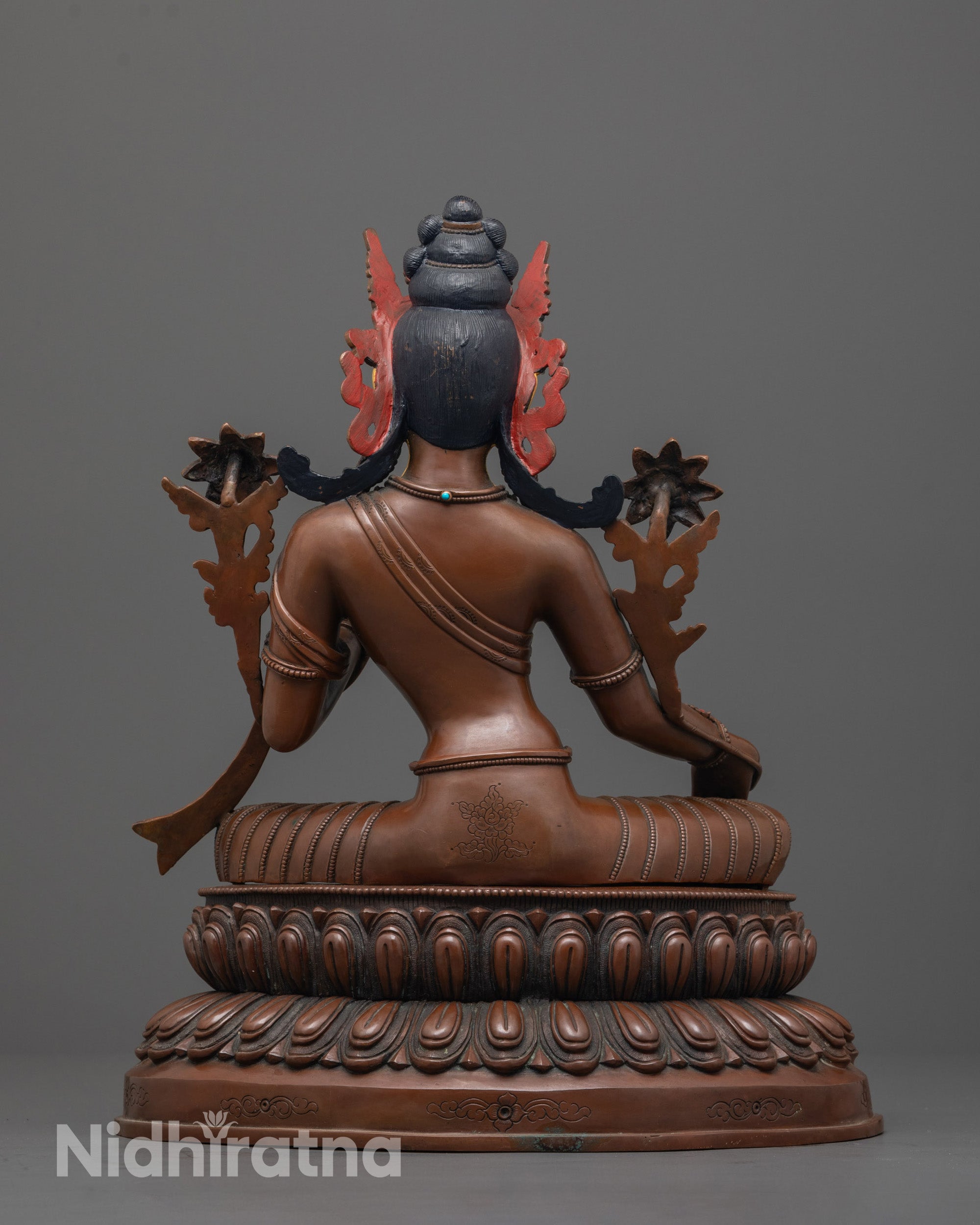 back view of handcrafted tara devi statue with detailed robe and oxidized copper body finish