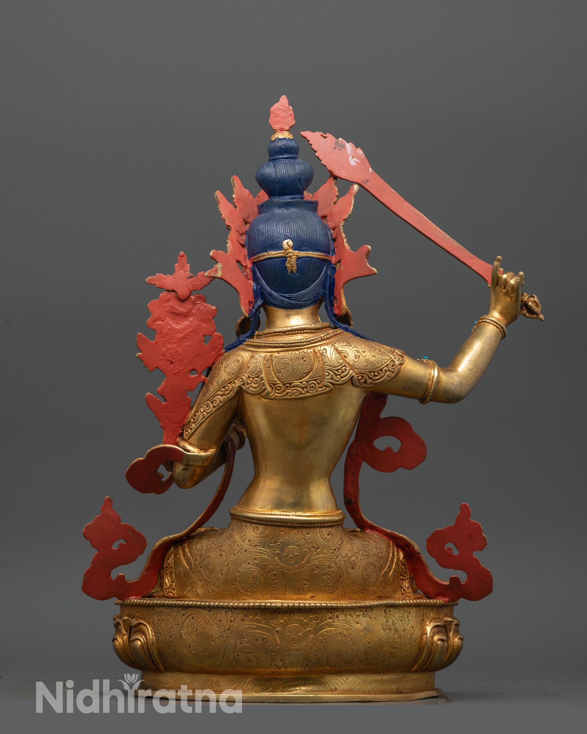 back view of manjushri statue showing detailed robe jewelry and lotus seat patterns in copper finish
