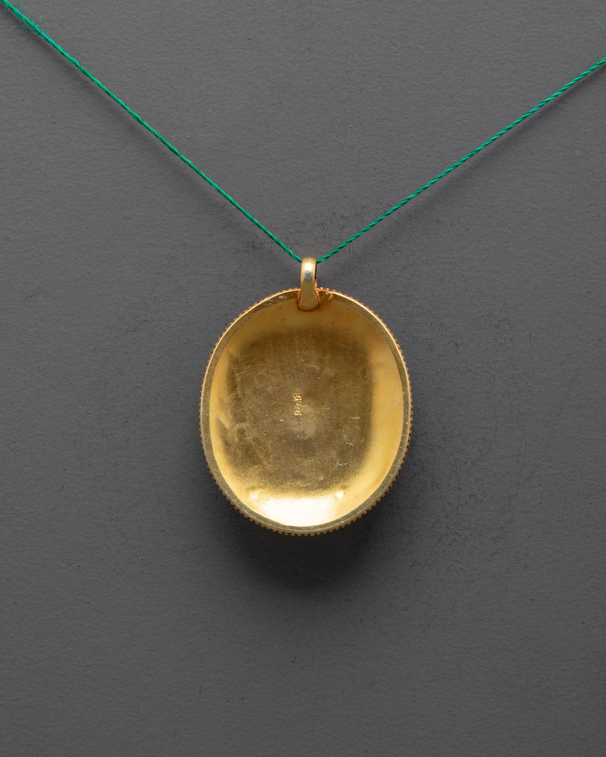 back view of traditional handcrafted flower locket from Patan with detailed copper carving