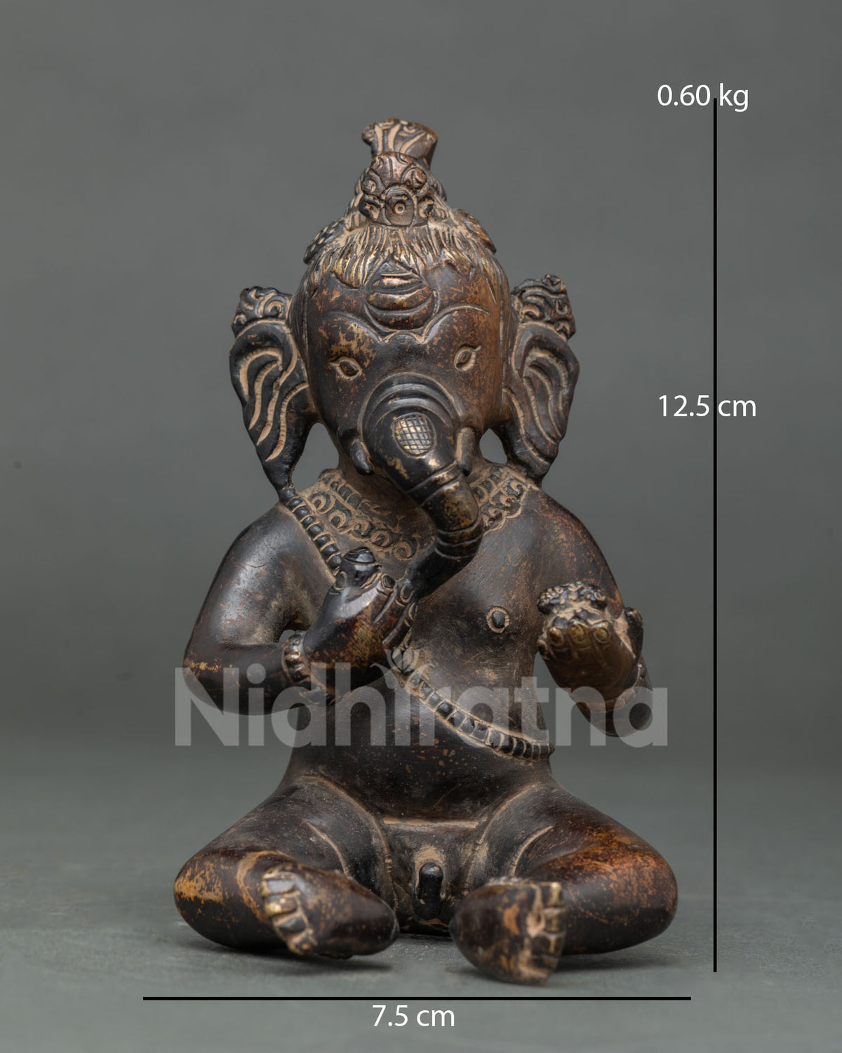 Bal Ganesha statue seated holding sweets, oxidized copper Buddhist artwork from Nepal, front view