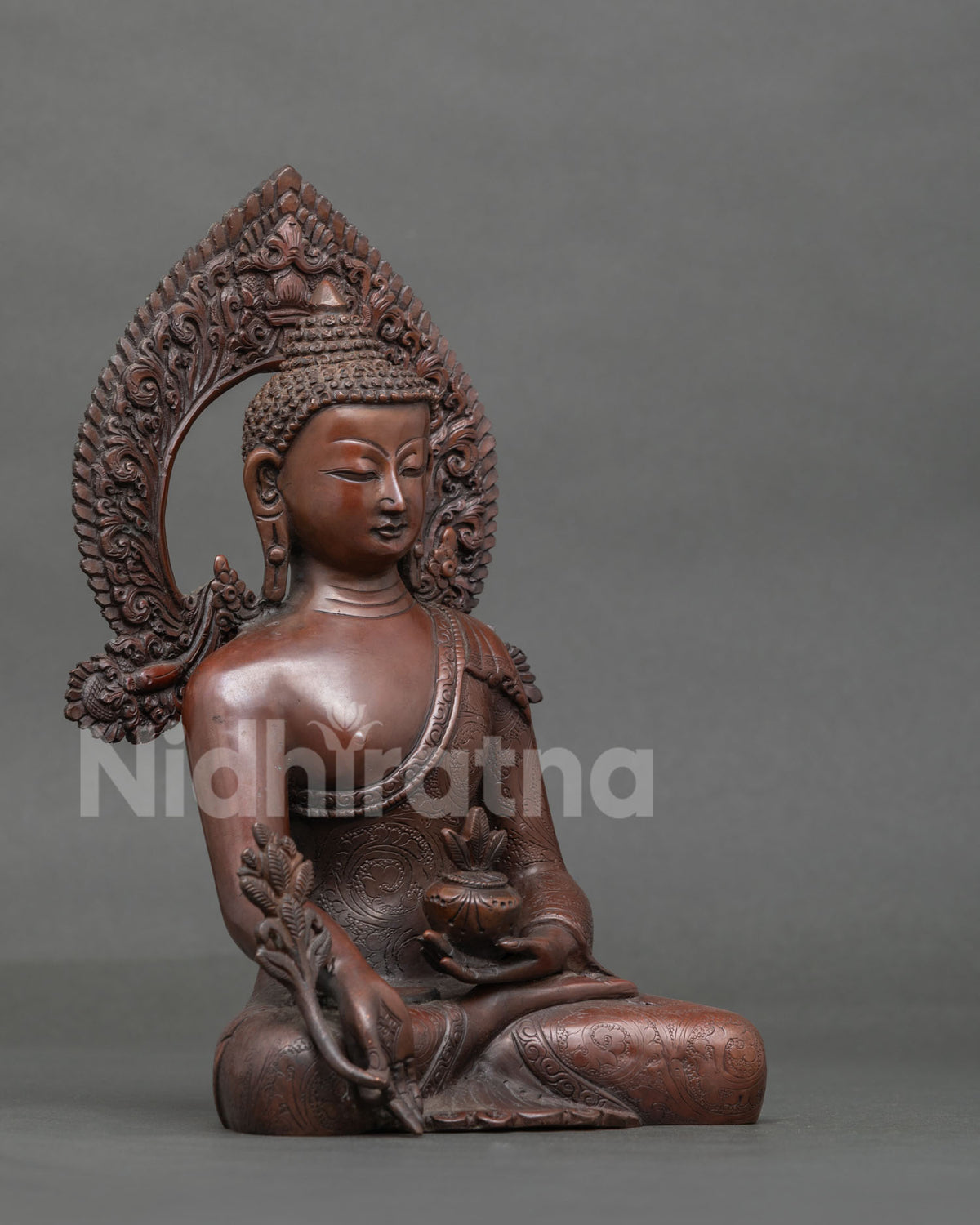 Bhaisajyaguru Buddha statue in oxidized copper with radiant halo and lotus seated posture