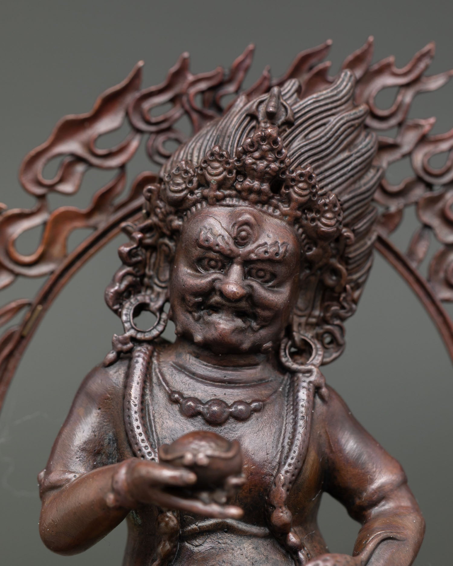 Black dzambhala statue showing intricate ornaments powerful expression and nepalese craftsmanship.