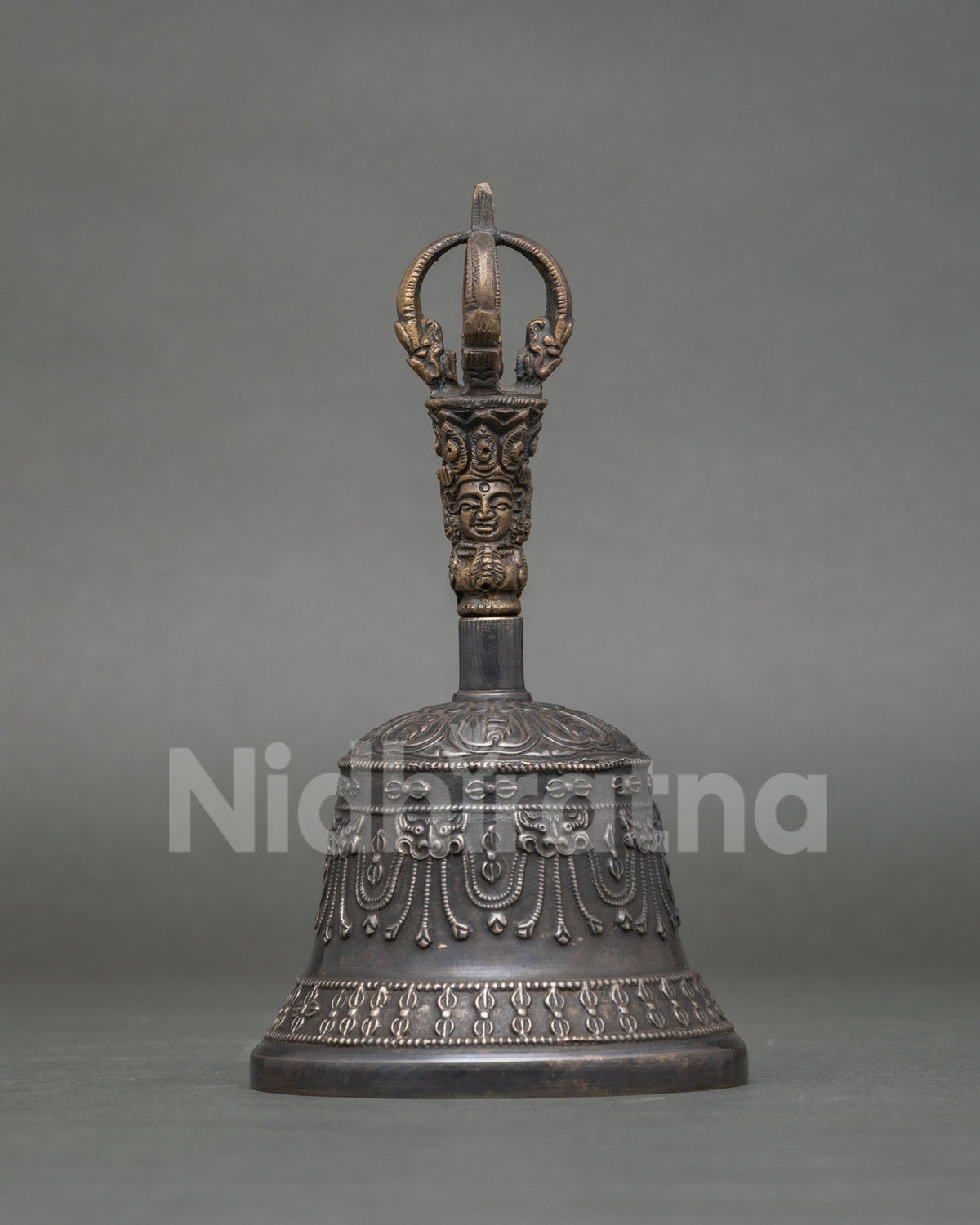 Buddhist bronze bell with brass handle featuring a beautifully carved deity