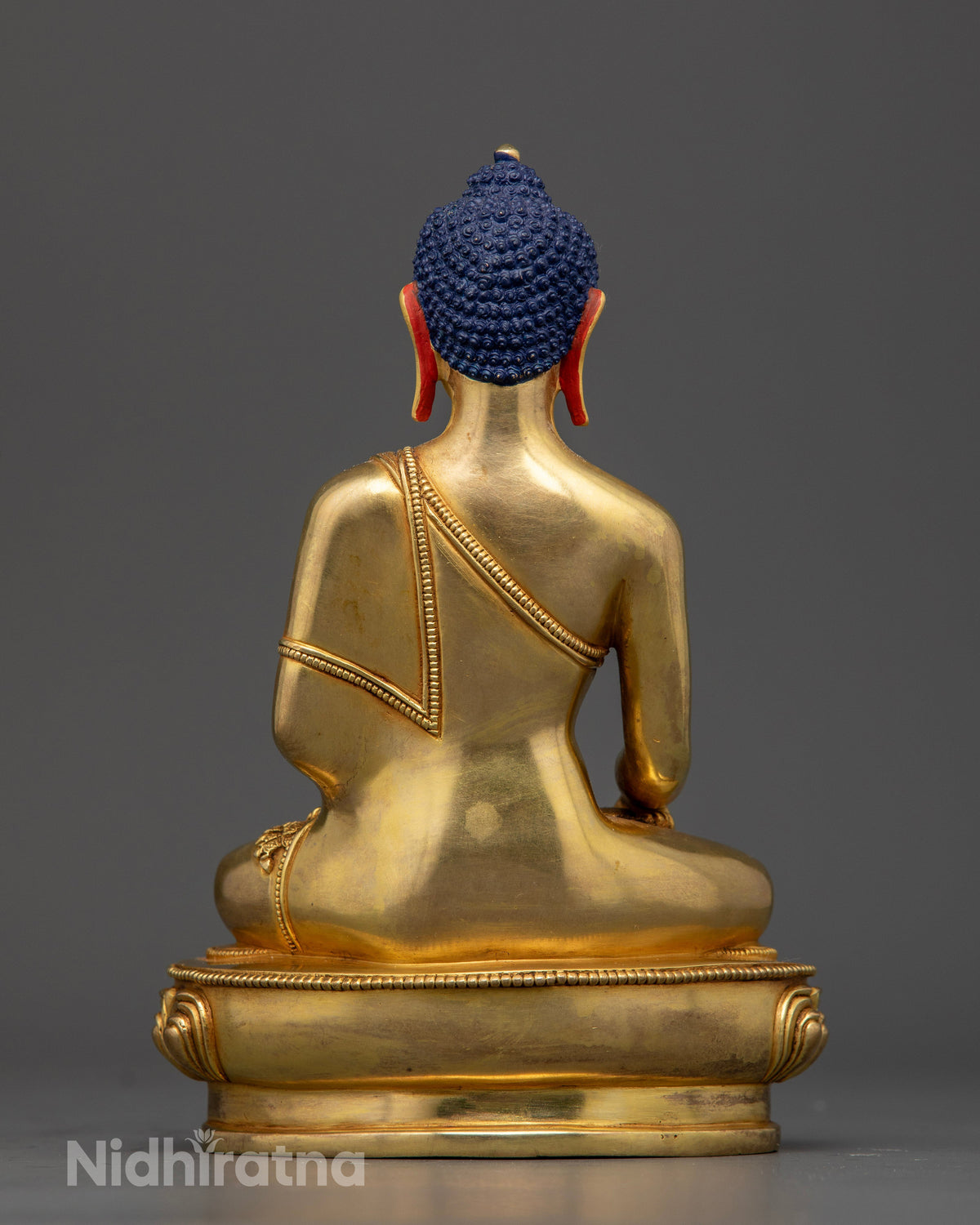 Buddhist statue made using lost-wax casting with a gold-painted face and intricate lotus pedestal