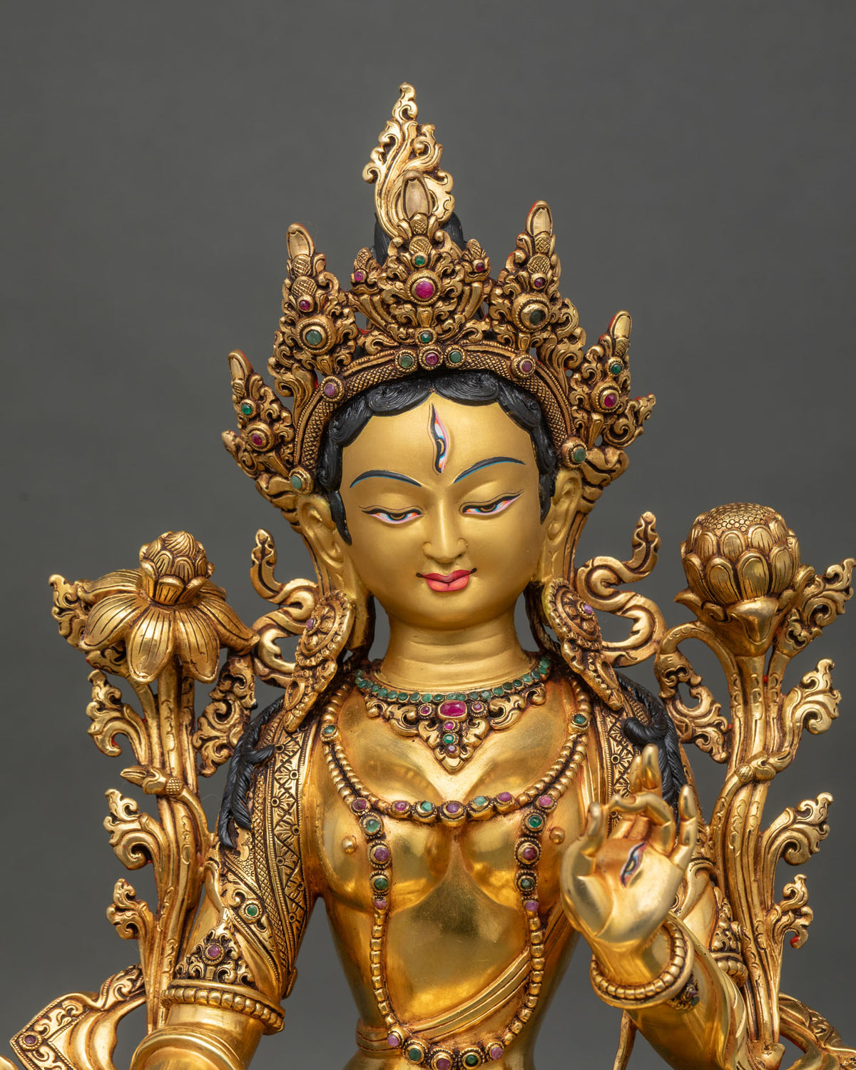 Buddhist White Tara statue close up showing jeweled crown and gold gilded copper details
