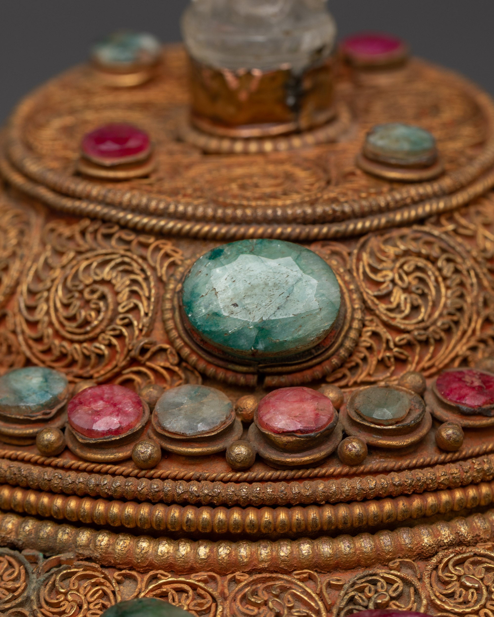 Close-up of carved deity figures on Dhirpur Rice Pot with detailed crown and vibrant stones