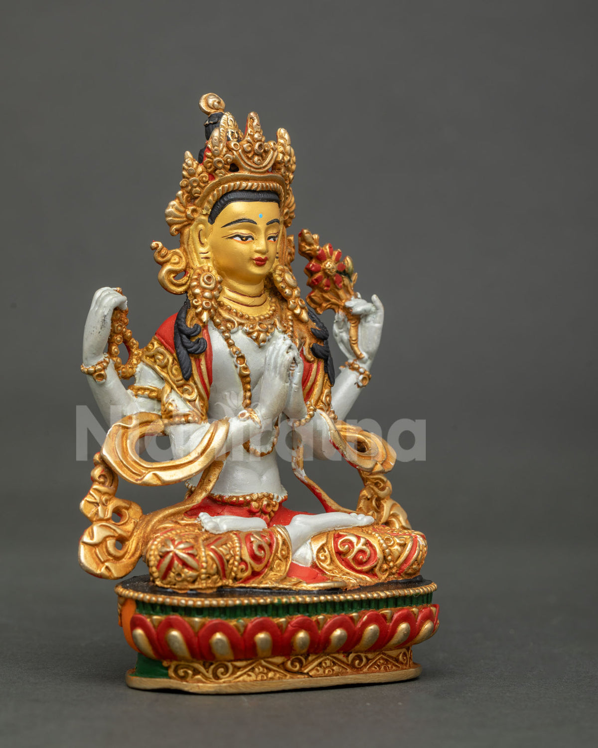 Chenrezig statue holding crystal rosary and blooming lotus flower.